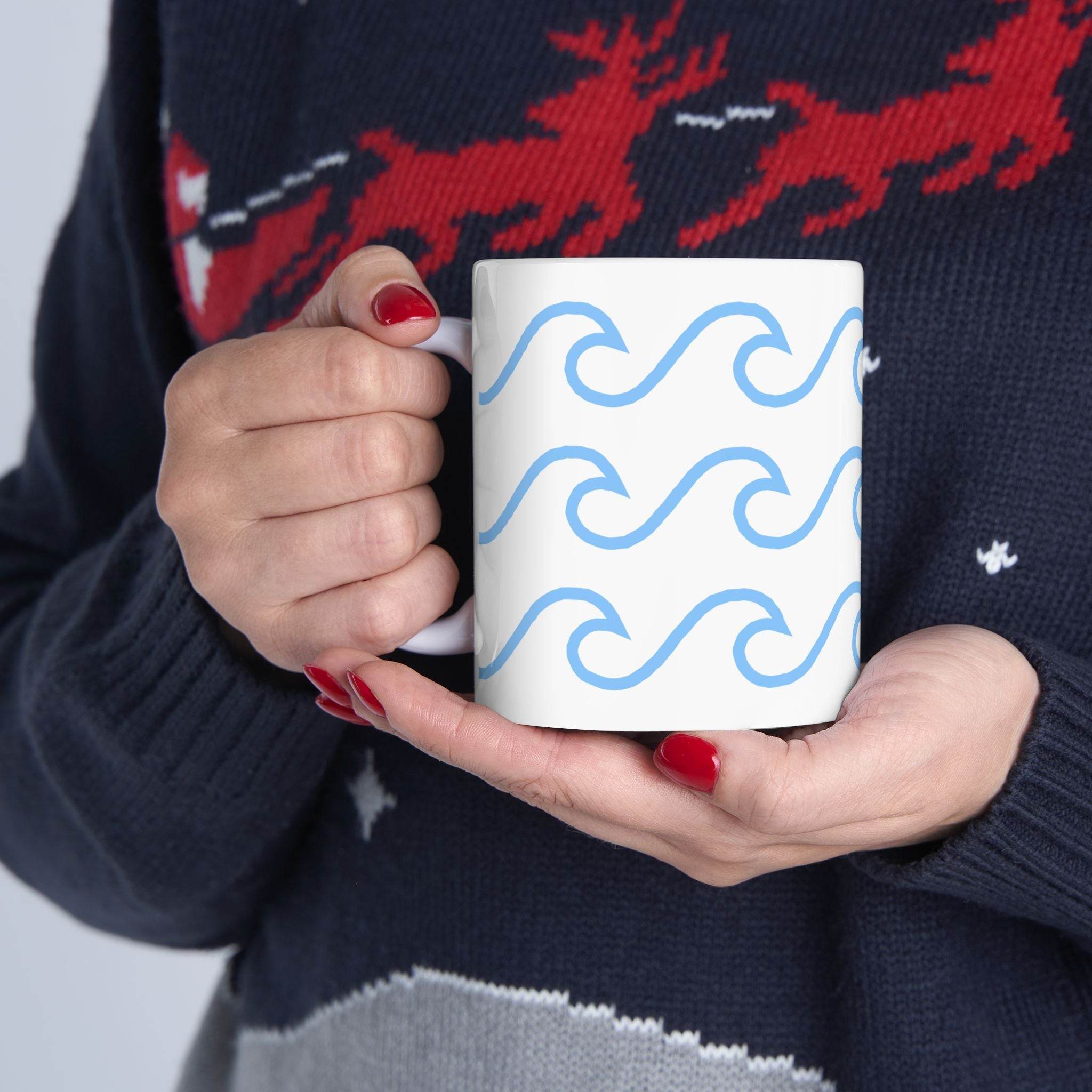 Printify ceramic mug with wave pattern held by person wearing a dark sweater with red and white design