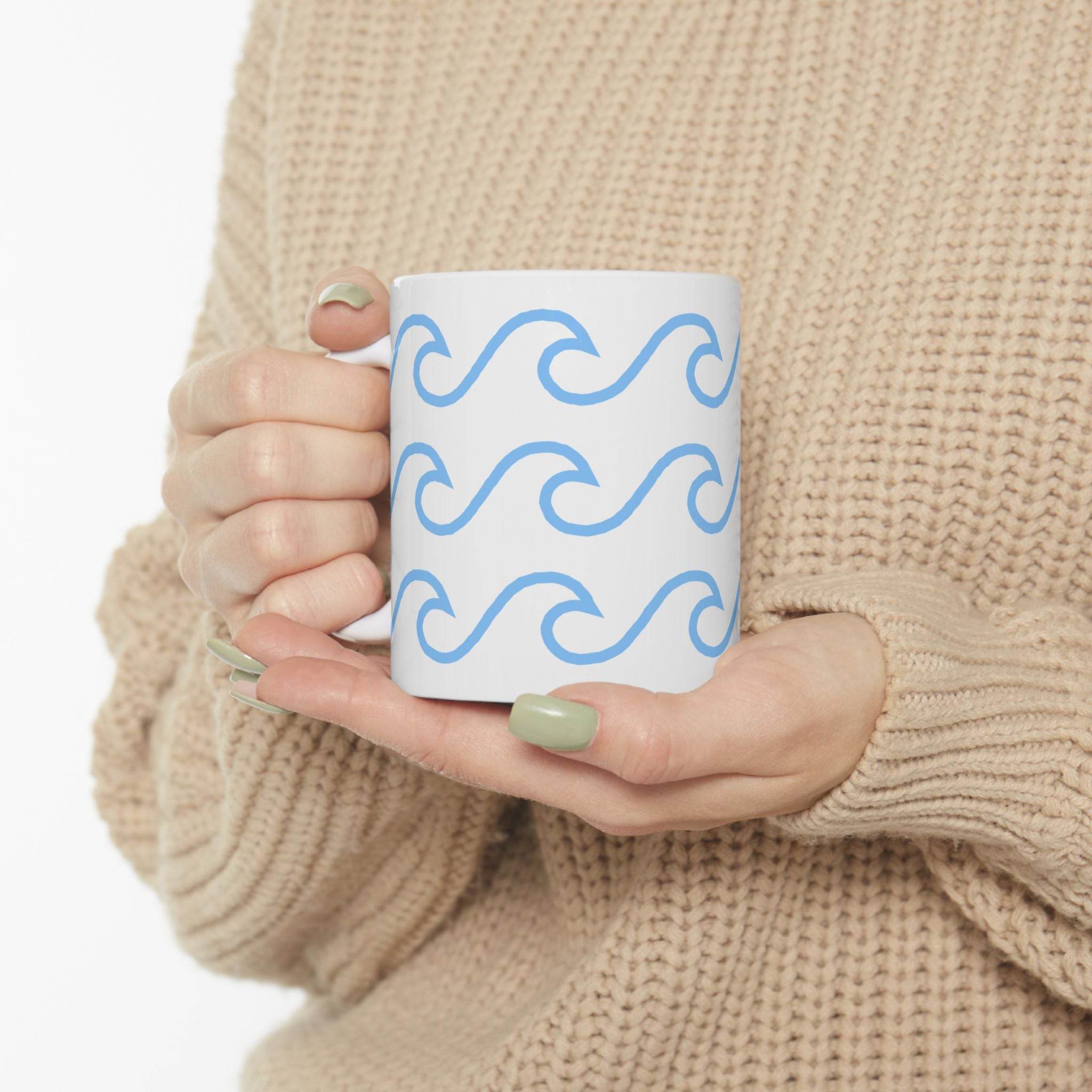 Printify ceramic mug with wave pattern in light blue held by person wearing beige sweater