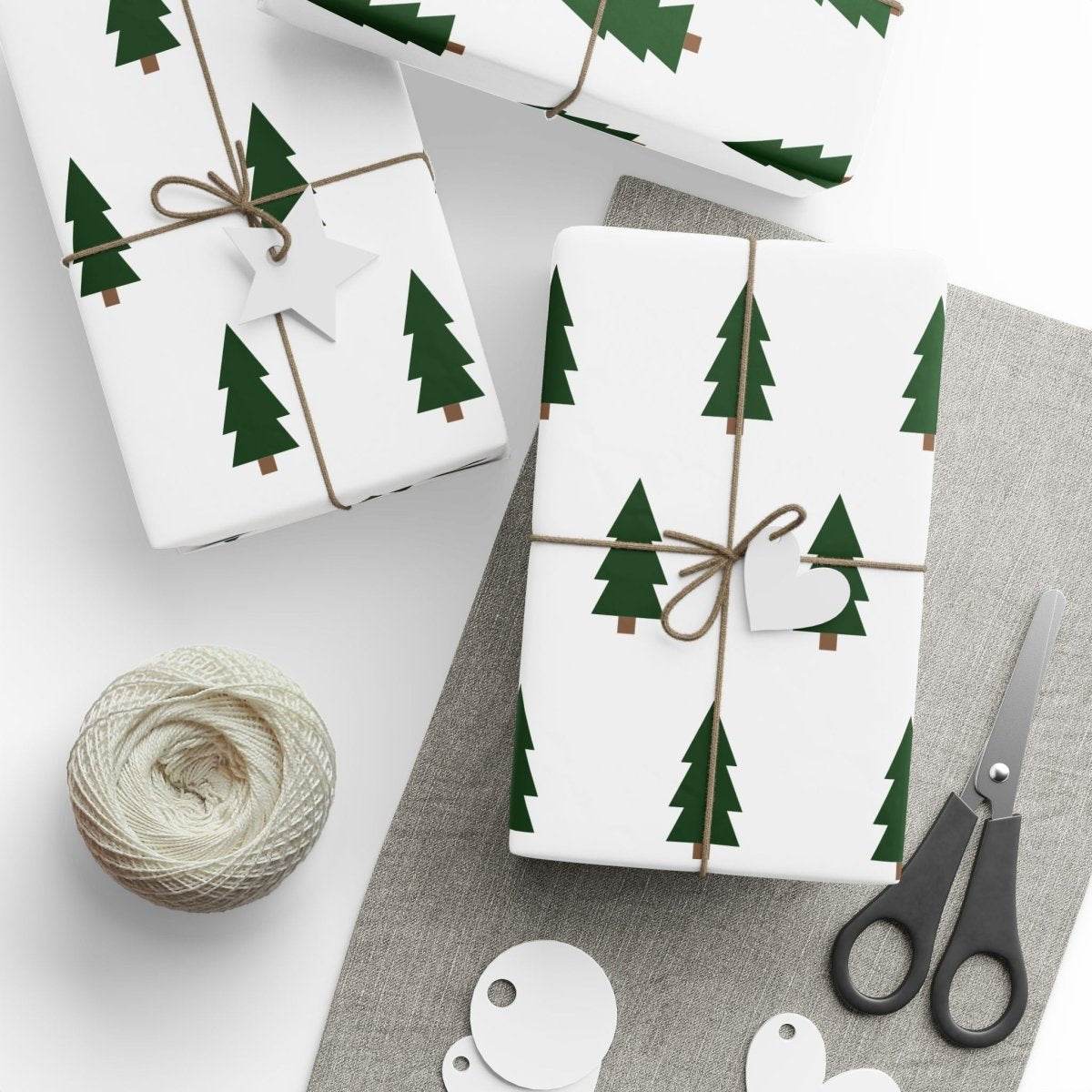 Christmas tree wrapping paper with green tree pattern on white background wrapped around gifts with twine and tags