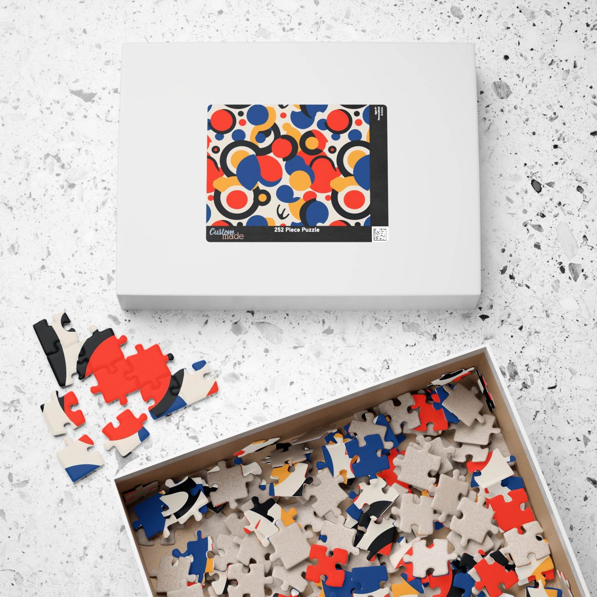 Printify colorful eco puzzle with abstract red blue and beige pieces in open box and white packaging