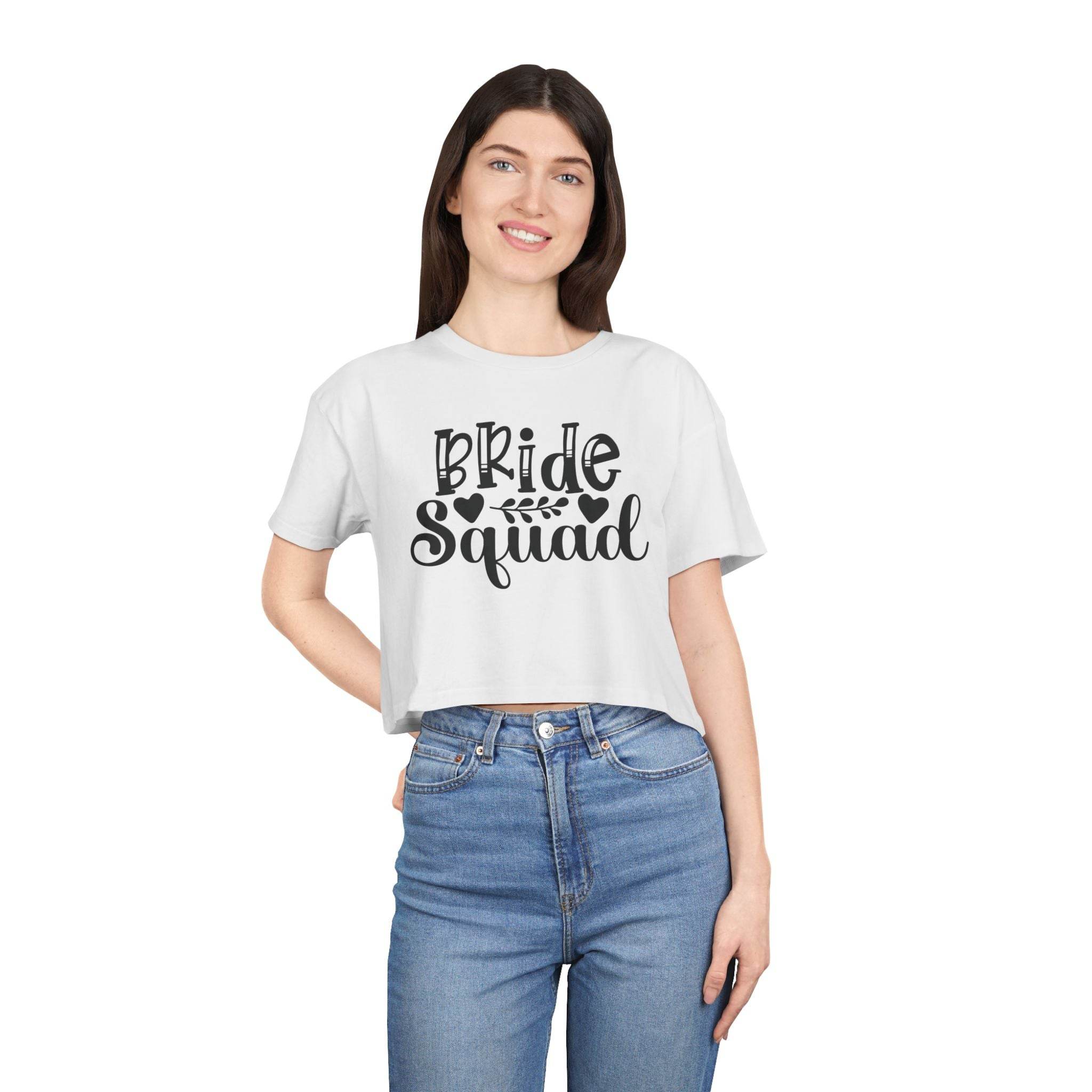 Smiling model wearing eco-friendly bride squad crop top in white with black script print and high waist jeans