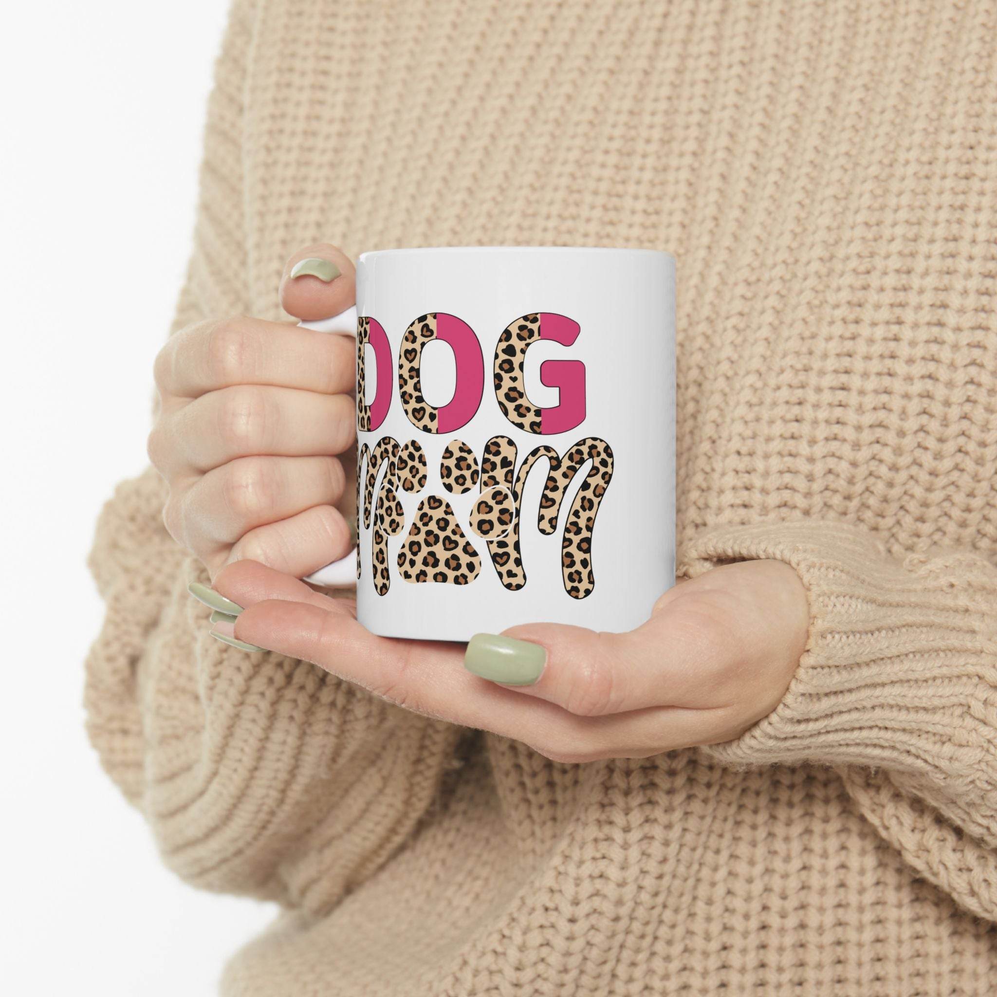 Person holding Printify eco friendly ceramic dog mom mug with leopard print and pink lettering on white mug