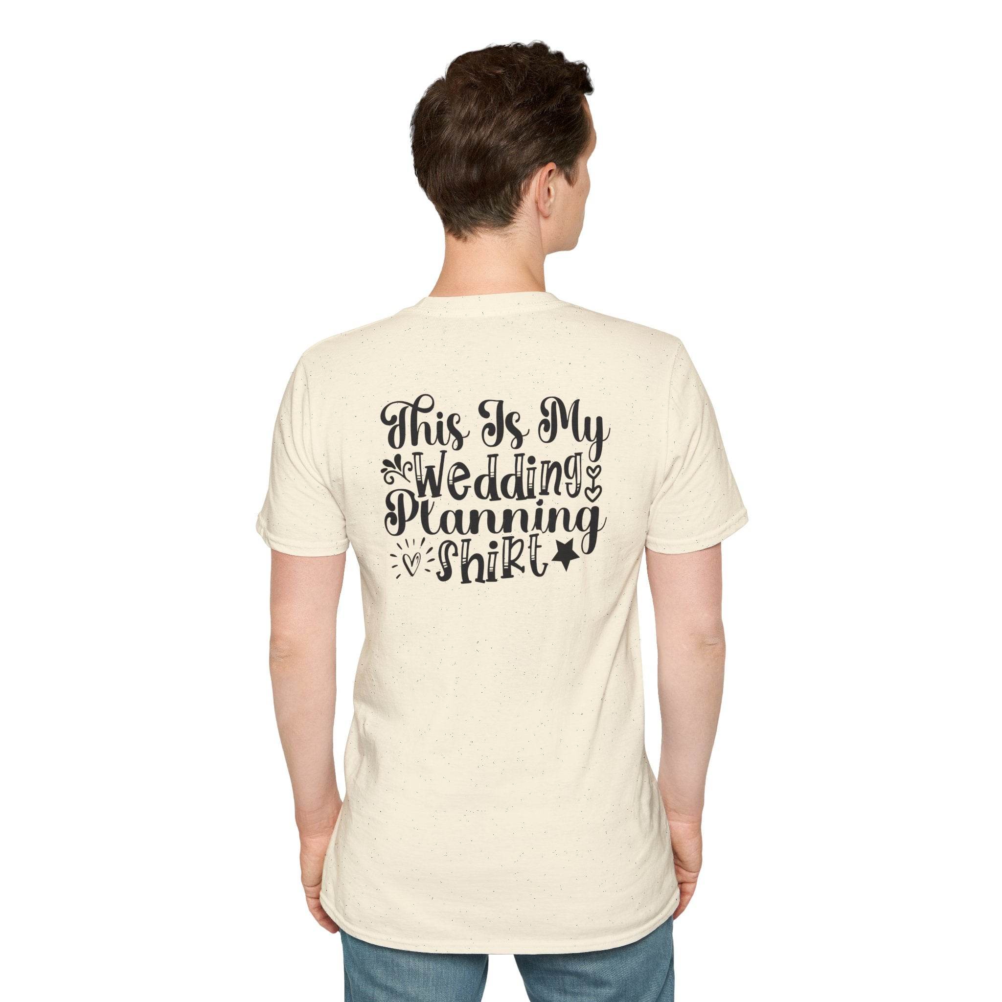 Male model wearing cream tee back showing black script text This Is My Wedding Planning Shirt eco-friendly wedding planning shirt