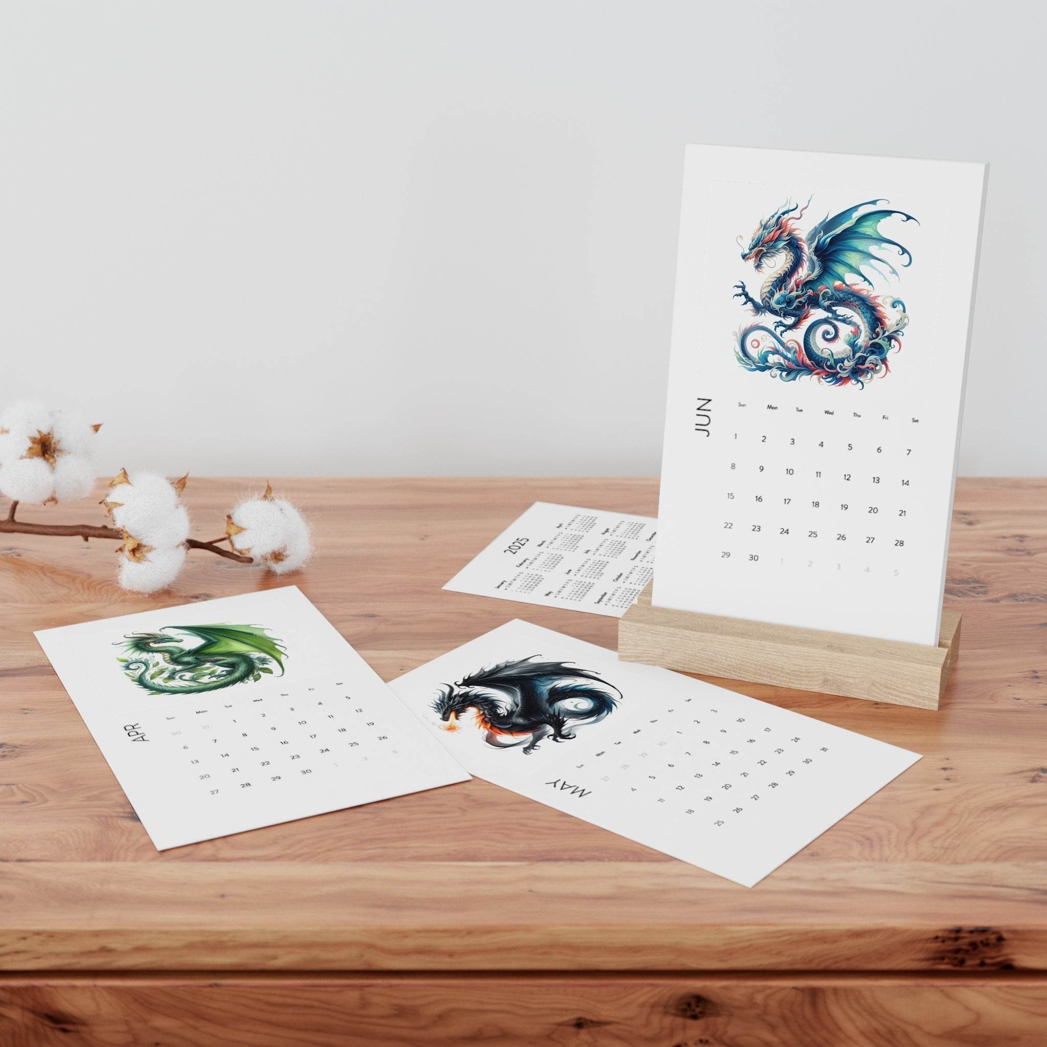 Printify eco-friendly 2025 desk calendar with dragon artwork on wooden stand and cotton flowers on table