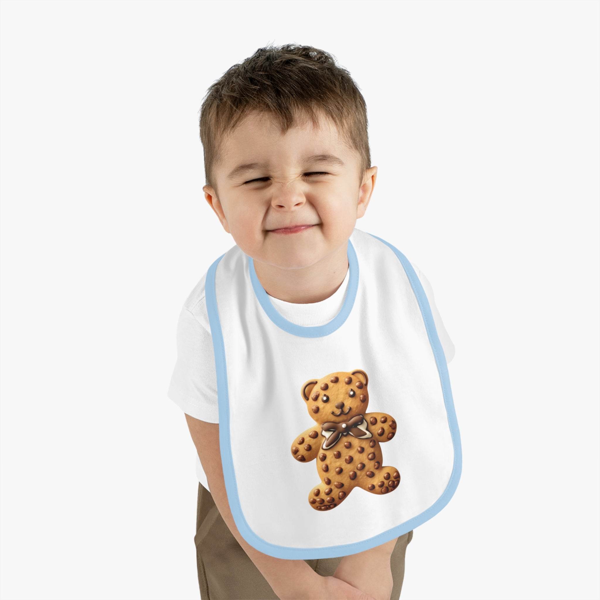 Toddler wearing Printify eco-friendly baby bib with cute teddy bear design and blue trim