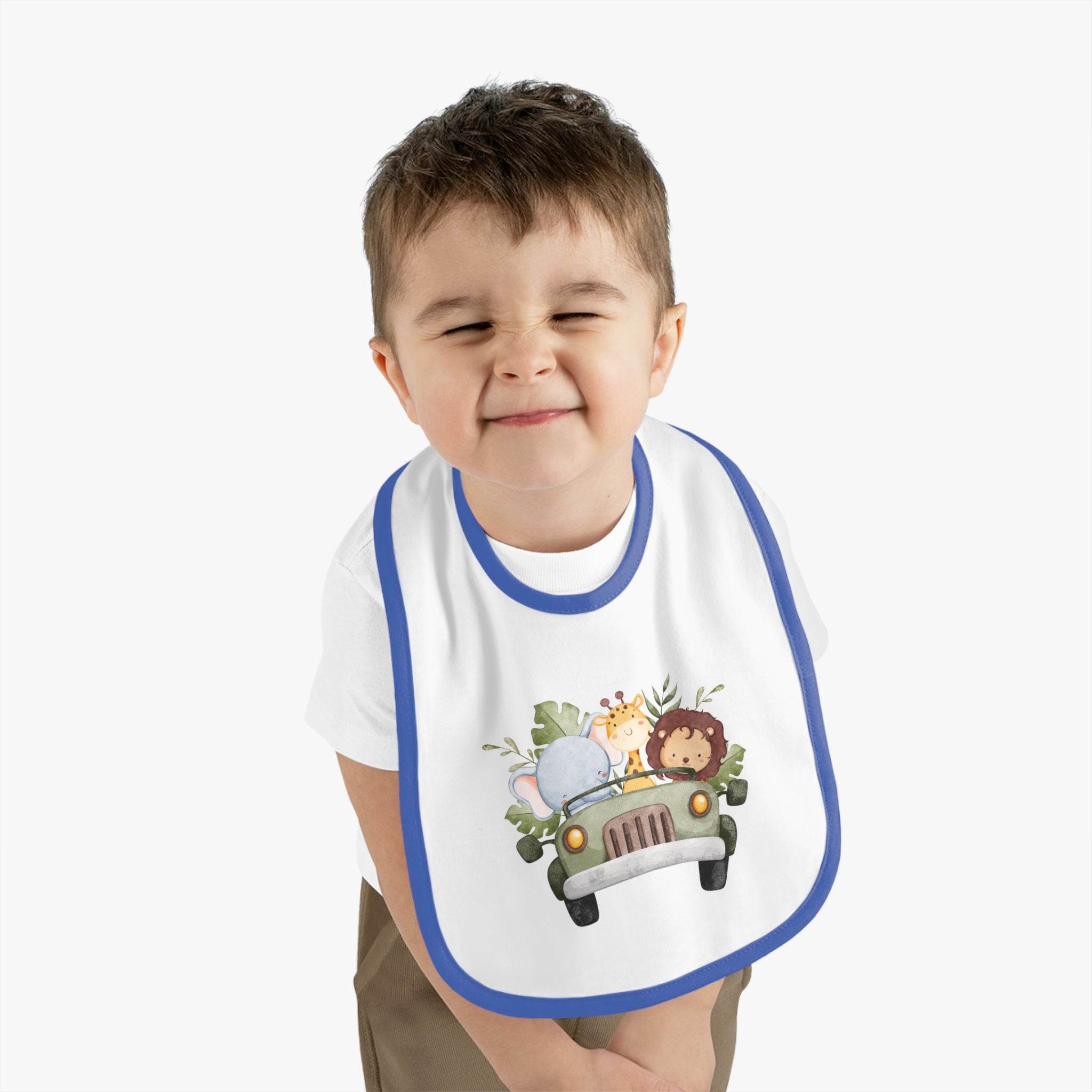 Toddler wearing a Printify eco-friendly baby bib with blue trim and cute jungle animal design