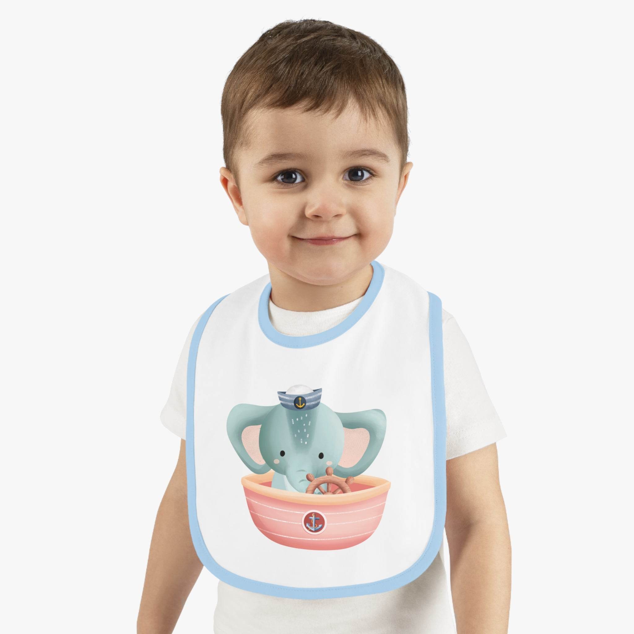 Smiling toddler wearing Printify eco-friendly baby bib with cute elephant sailor design and blue trim