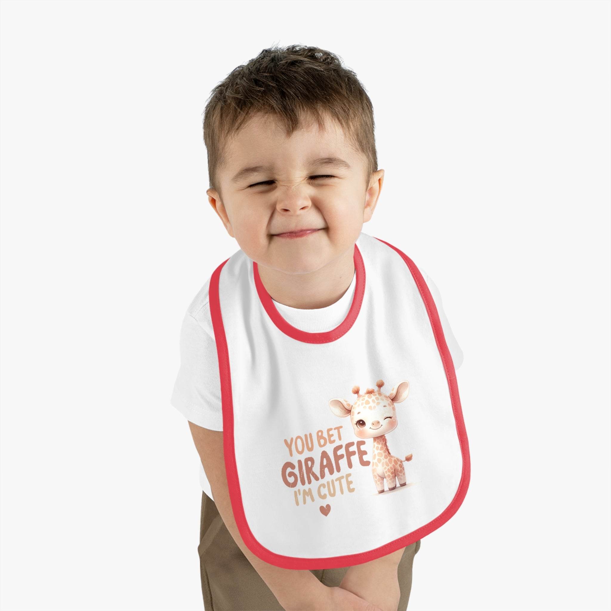 Eco-friendly baby bib with pink trim featuring a cute giraffe design and text worn by a smiling toddler