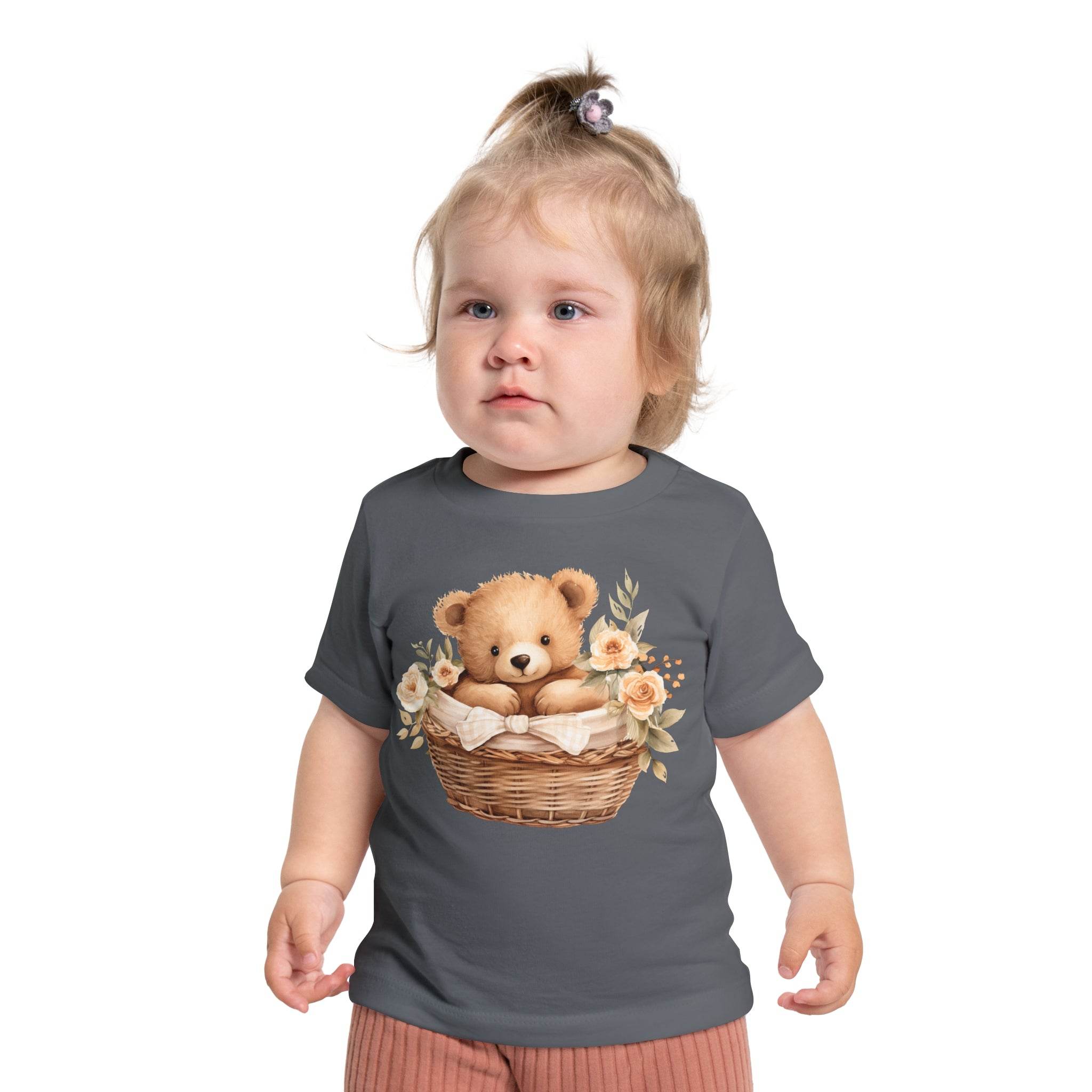 Toddler wearing Printify eco-friendly baby t-shirt with teddy bear in basket and floral design