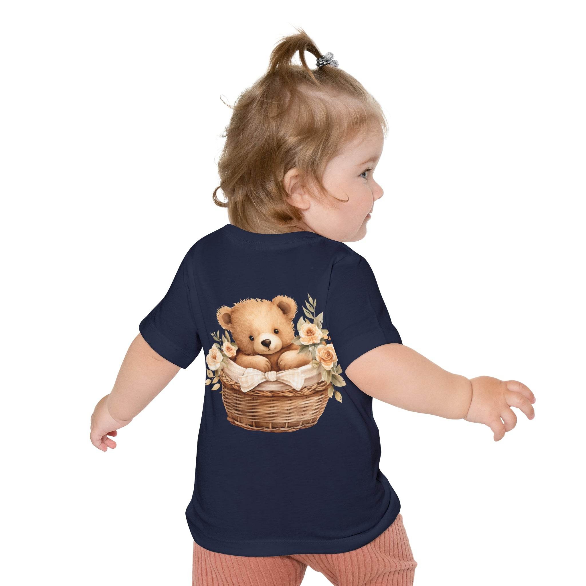 Toddler wearing navy eco-friendly baby t-shirt with teddy bear and floral basket design from Printify