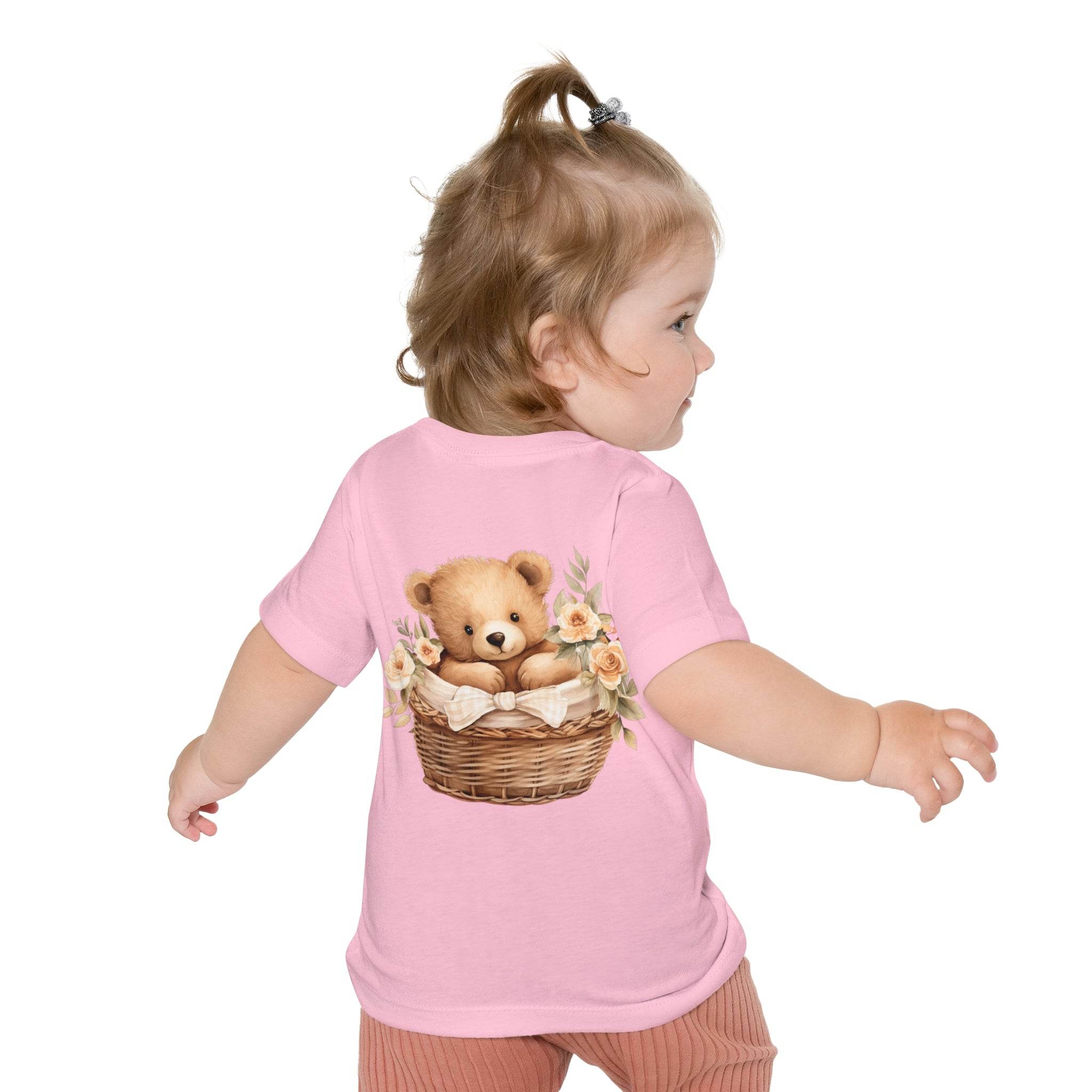 Toddler wearing pink eco-friendly baby t-shirt with teddy bear in basket floral design on back