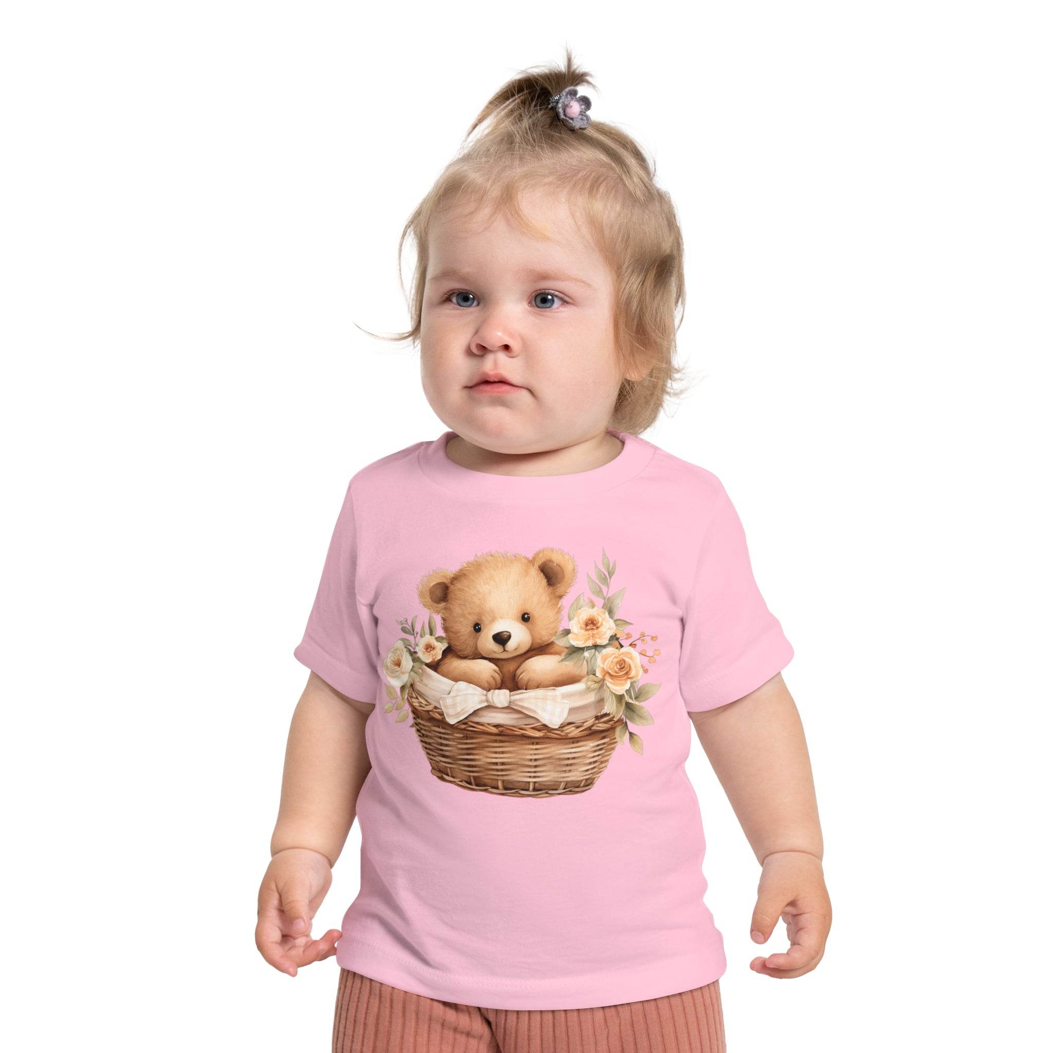 Toddler wearing a pink eco-friendly baby t-shirt with a teddy bear in a basket print from Printify