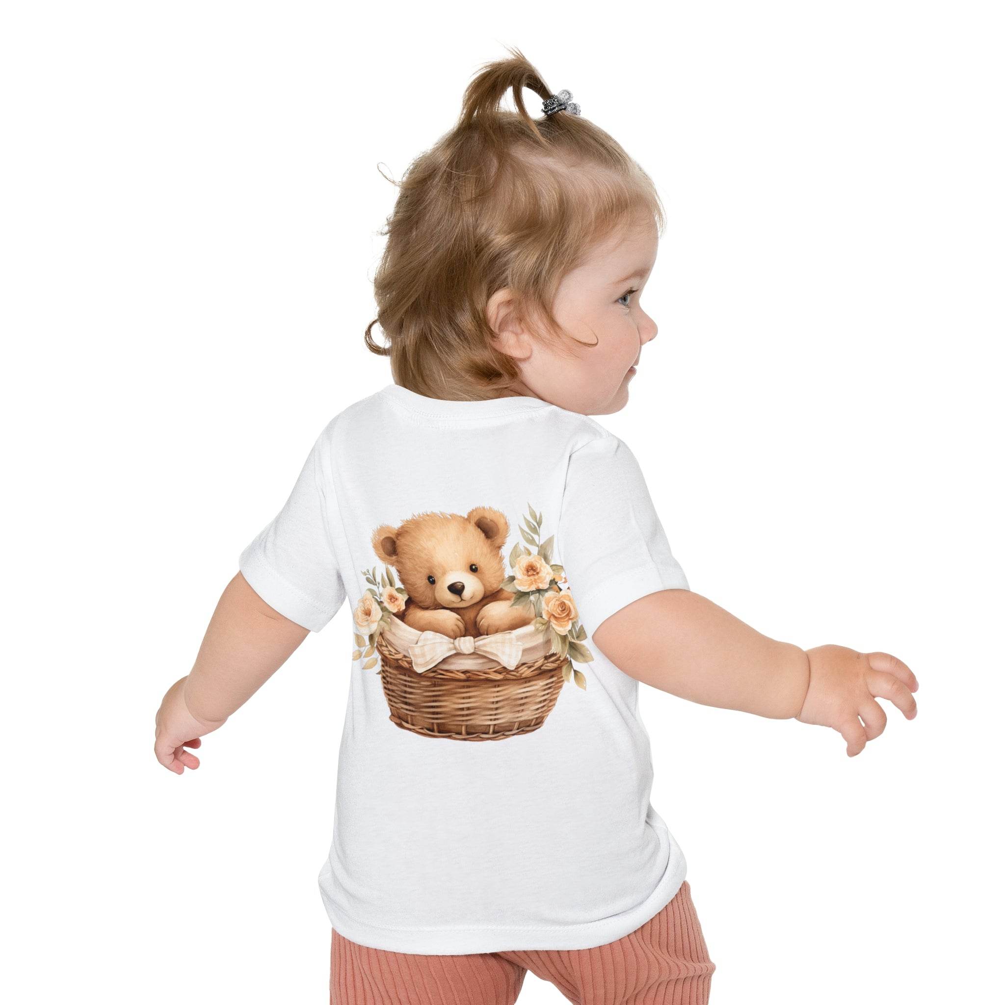 Toddler wearing Printify eco-friendly baby t-shirt with teddy bear in basket design on back