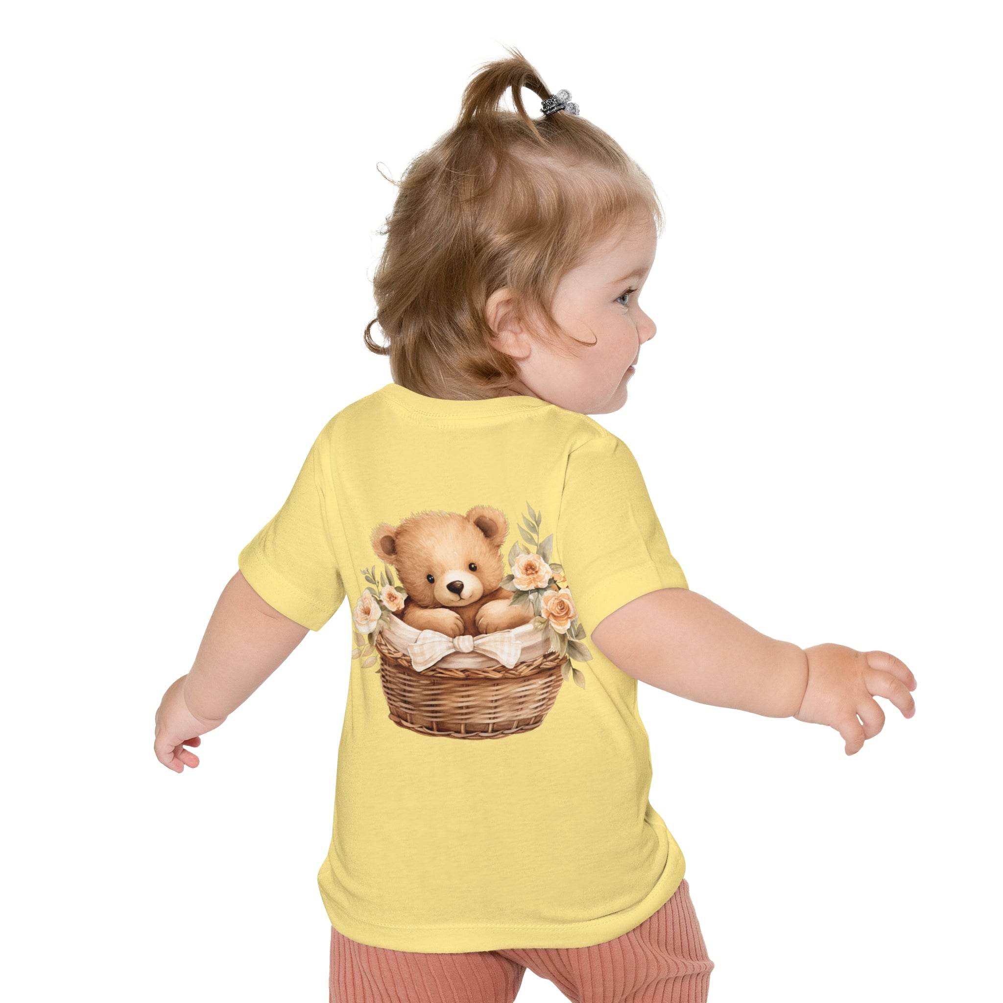 Toddler wearing a yellow eco-friendly baby t-shirt with a teddy bear in a basket print on the back