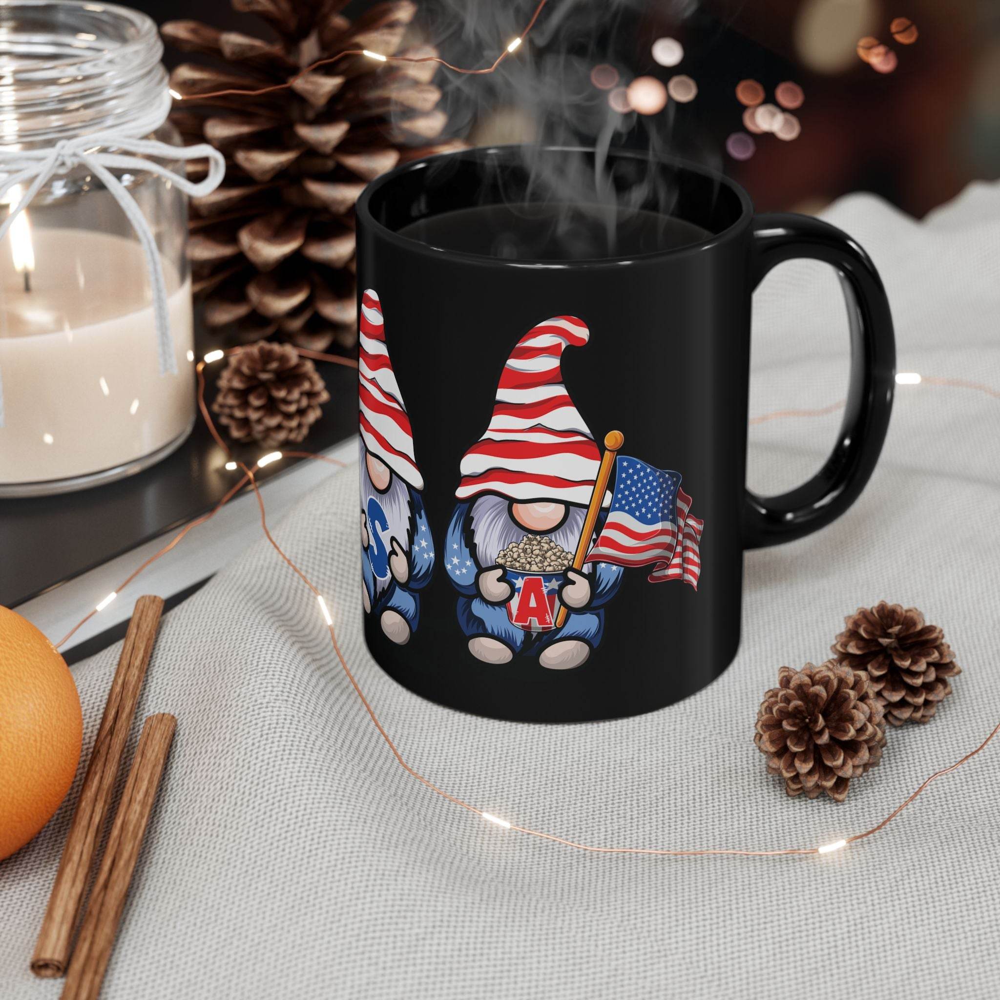 Printify eco-friendly black mug with patriotic gnome holding an American flag on a cozy holiday table