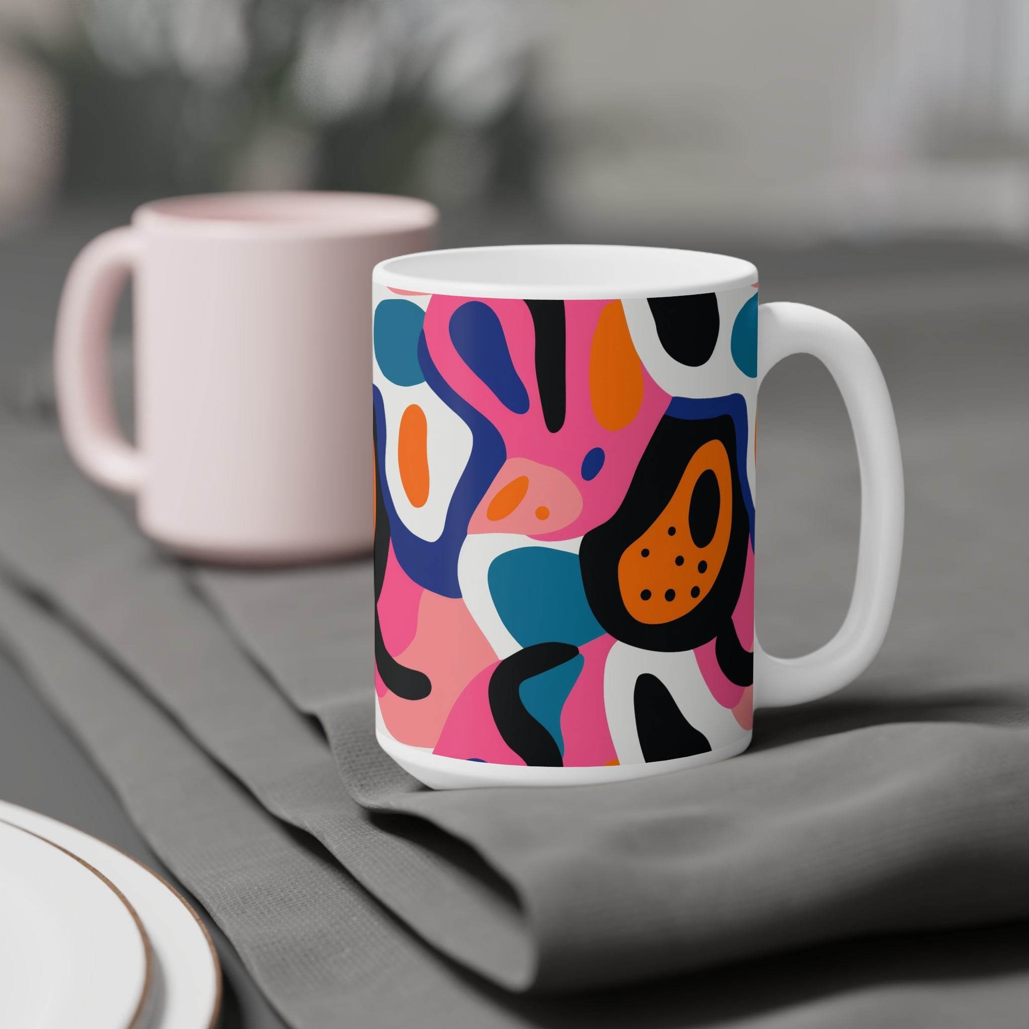 Printify eco-friendly ceramic mugs with colorful abstract design placed on gray fabric