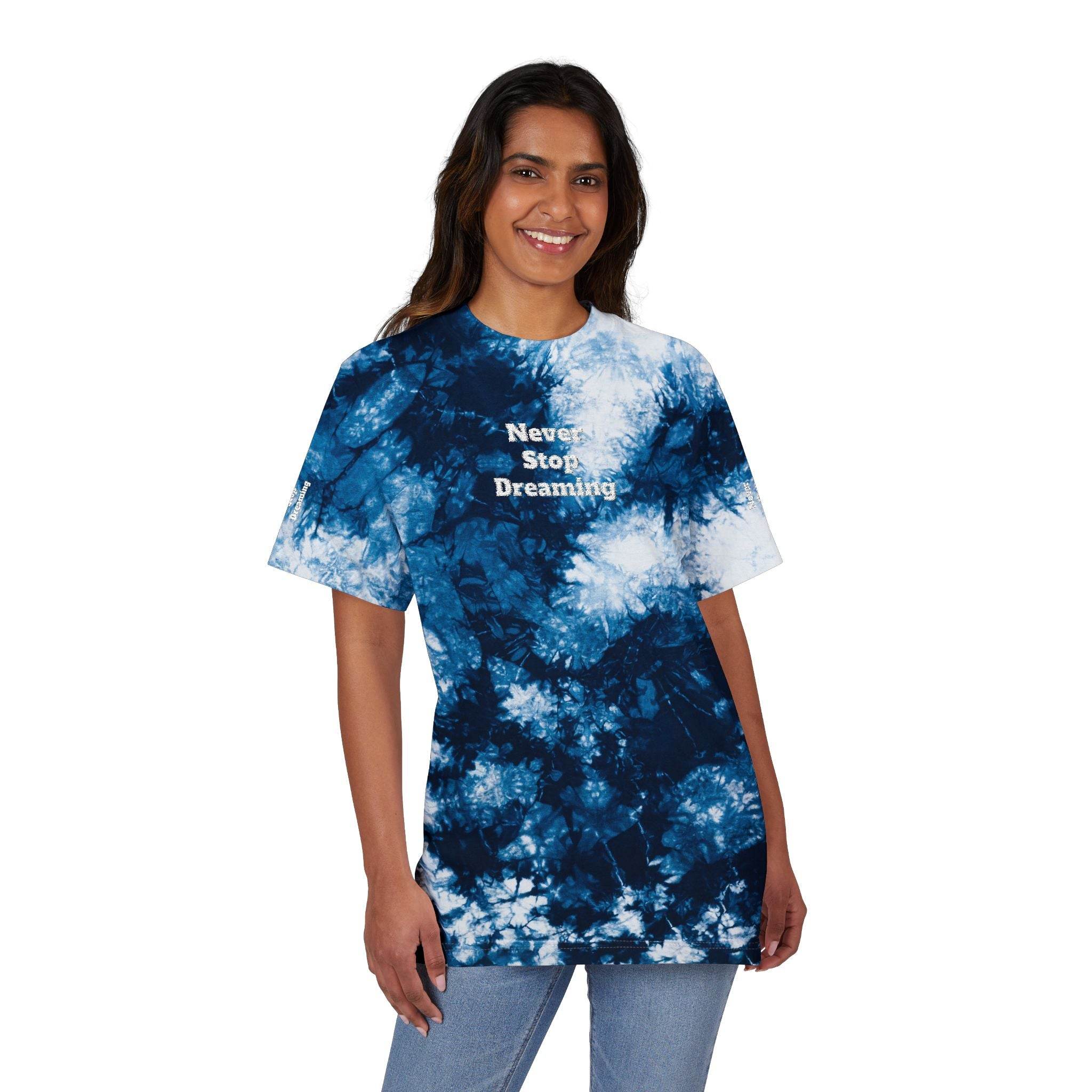 Woman wearing Printify eco-friendly embroidered shirt with blue tie-dye pattern and Never Stop Dreaming text