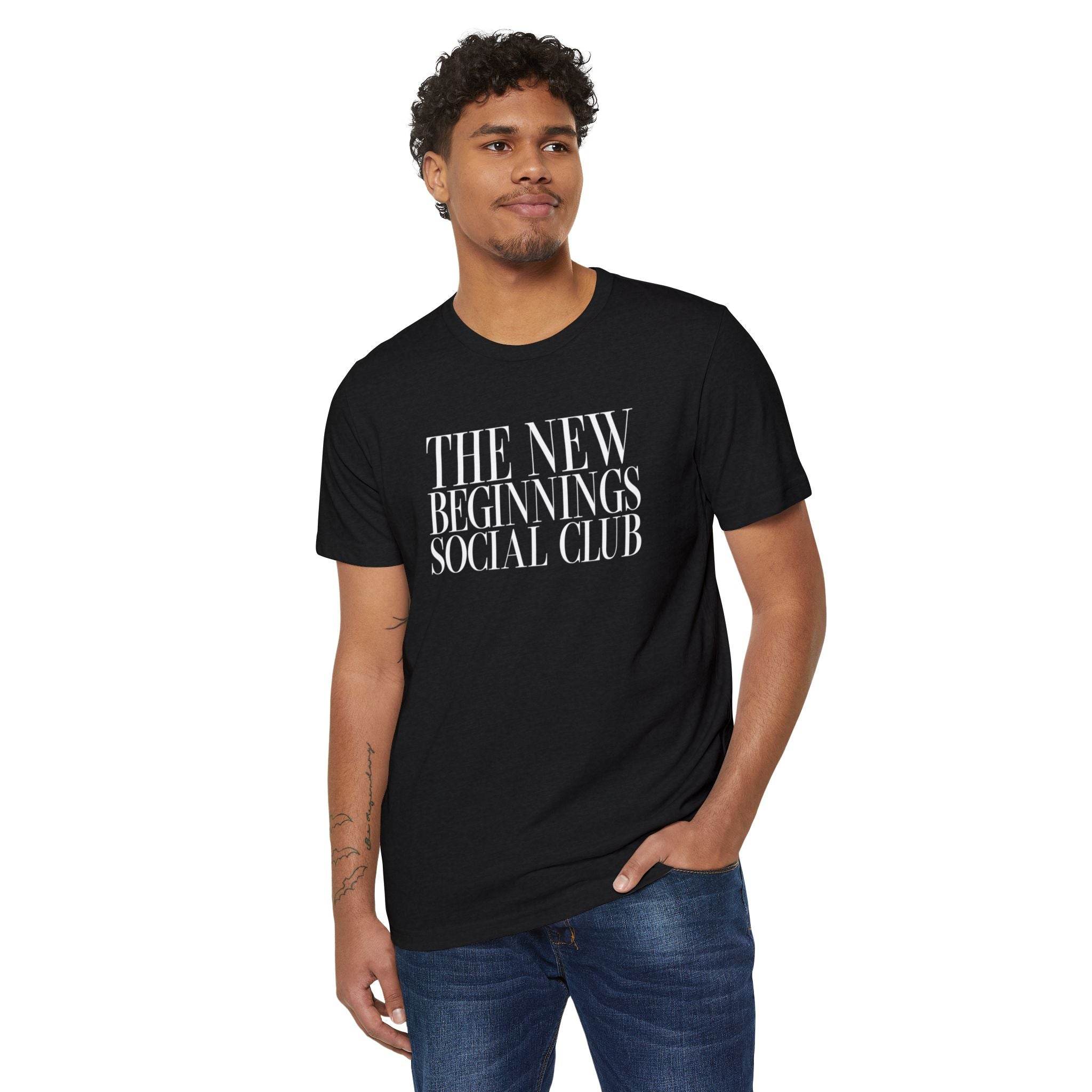 Printify black eco-friendly fashion tee with The New Beginnings Social Club text worn by man