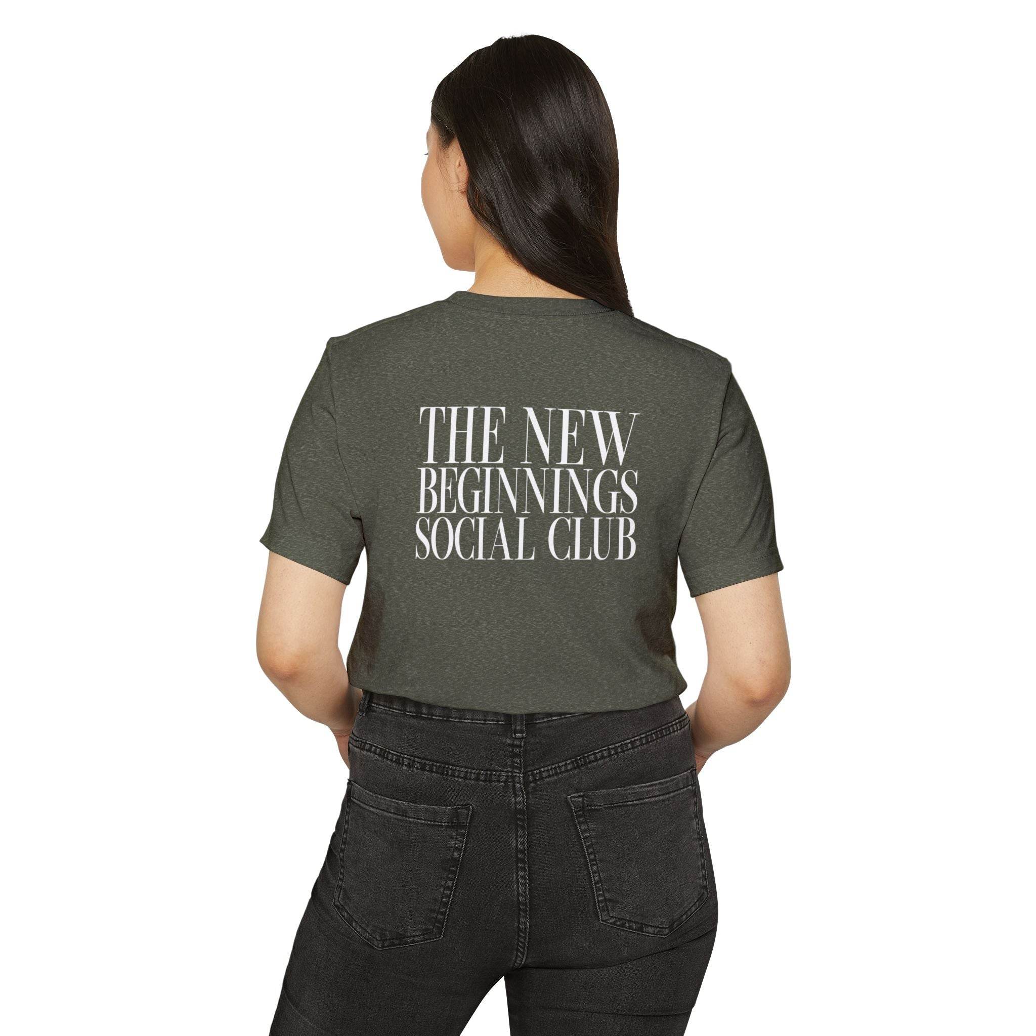 Printify eco-friendly fashion tee with The New Beginnings Social Club text on the back in dark green color