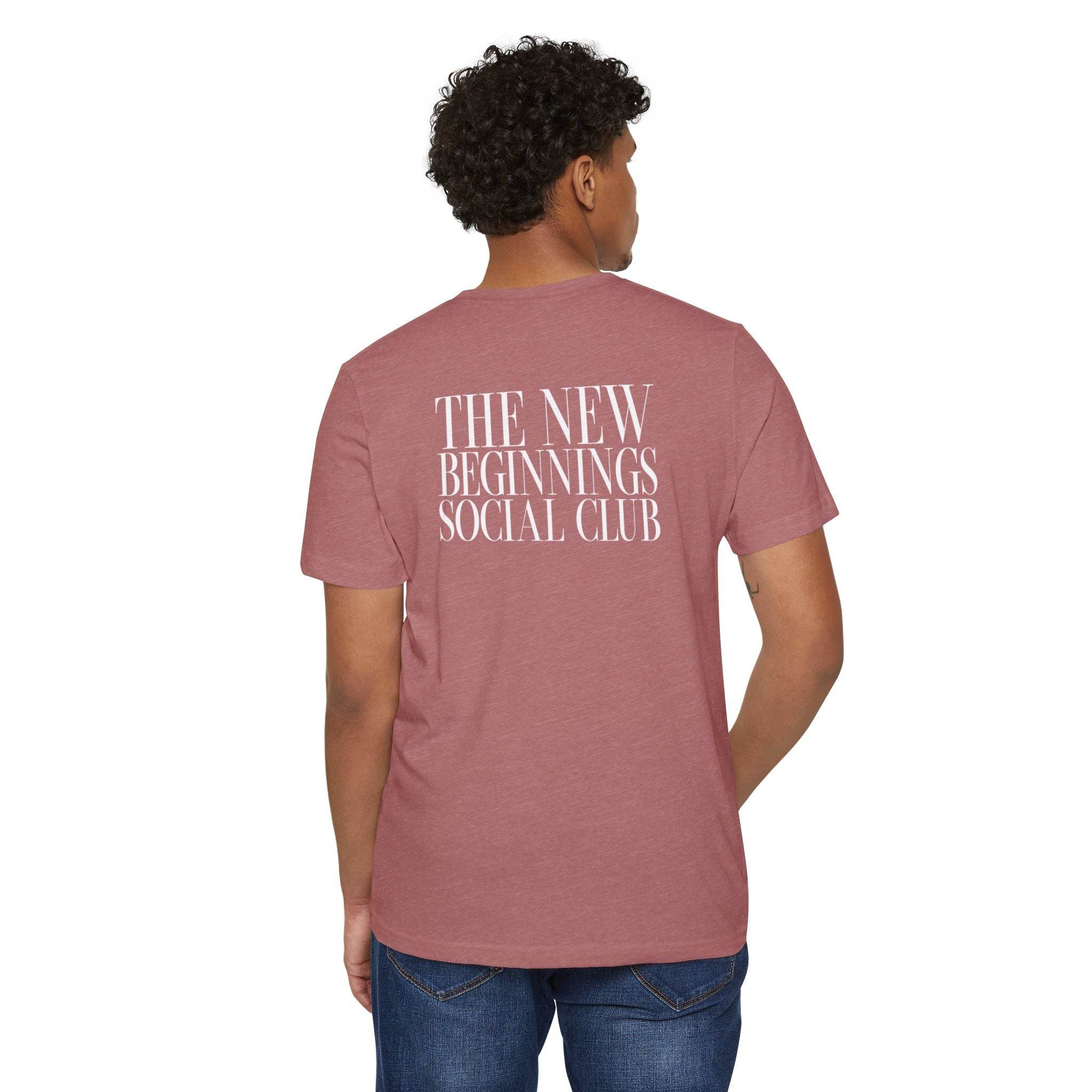Back view of a man wearing a mauve Printify eco-friendly fashion tee with The New Beginnings Social Club text