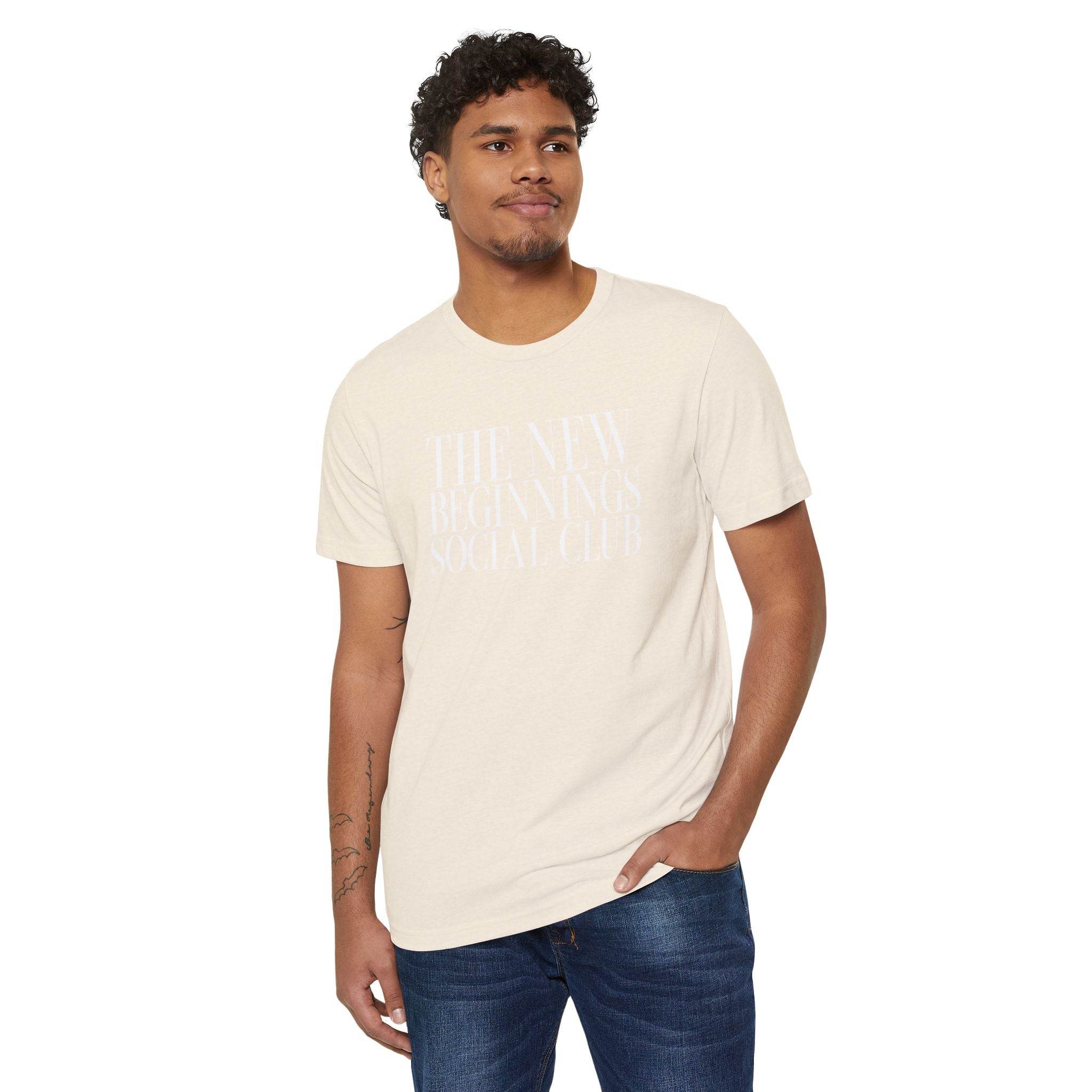 Printify eco-friendly fashion tee in light beige with white text worn by man with jeans