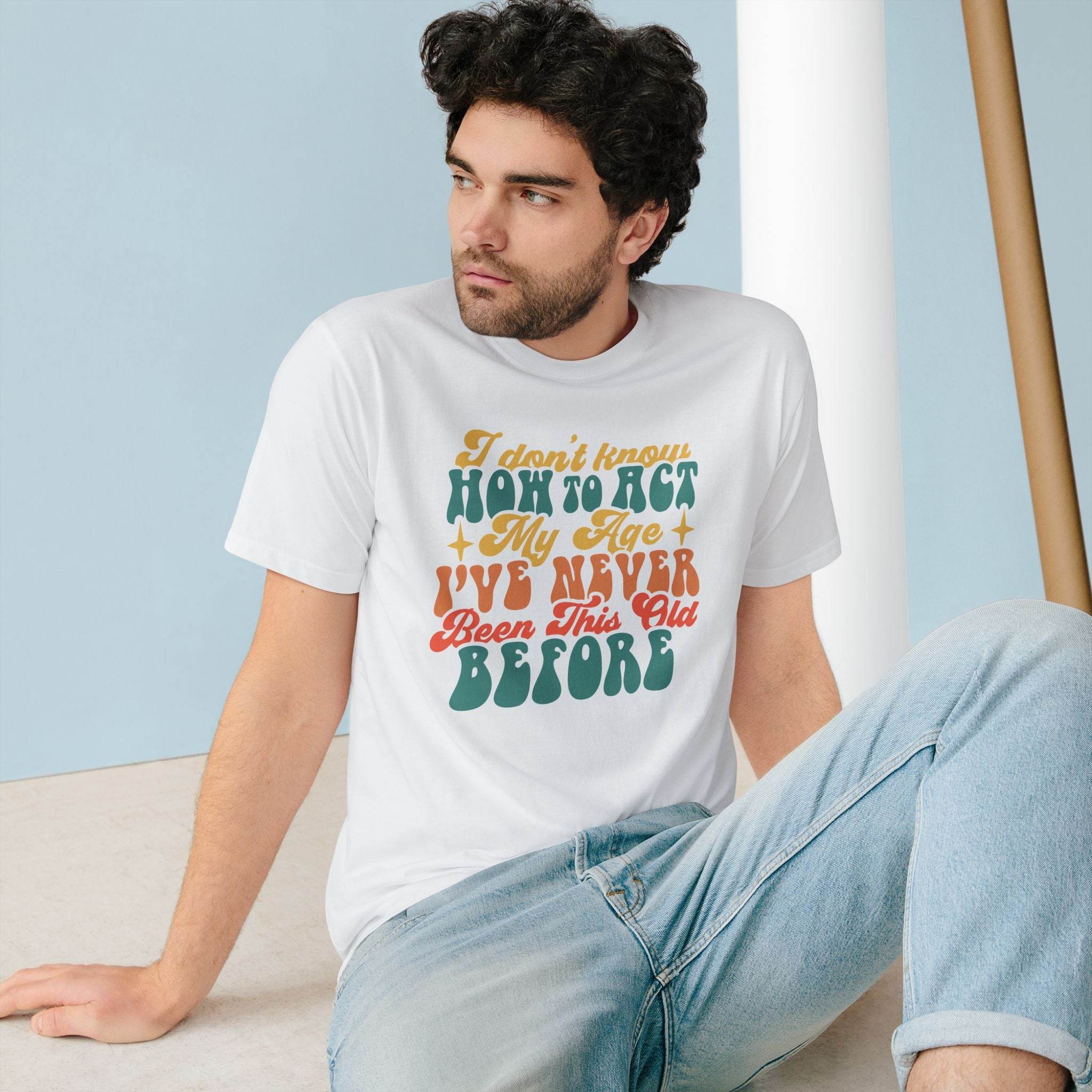 Printify eco-friendly graphic tee with colorful vintage text design worn by a seated man