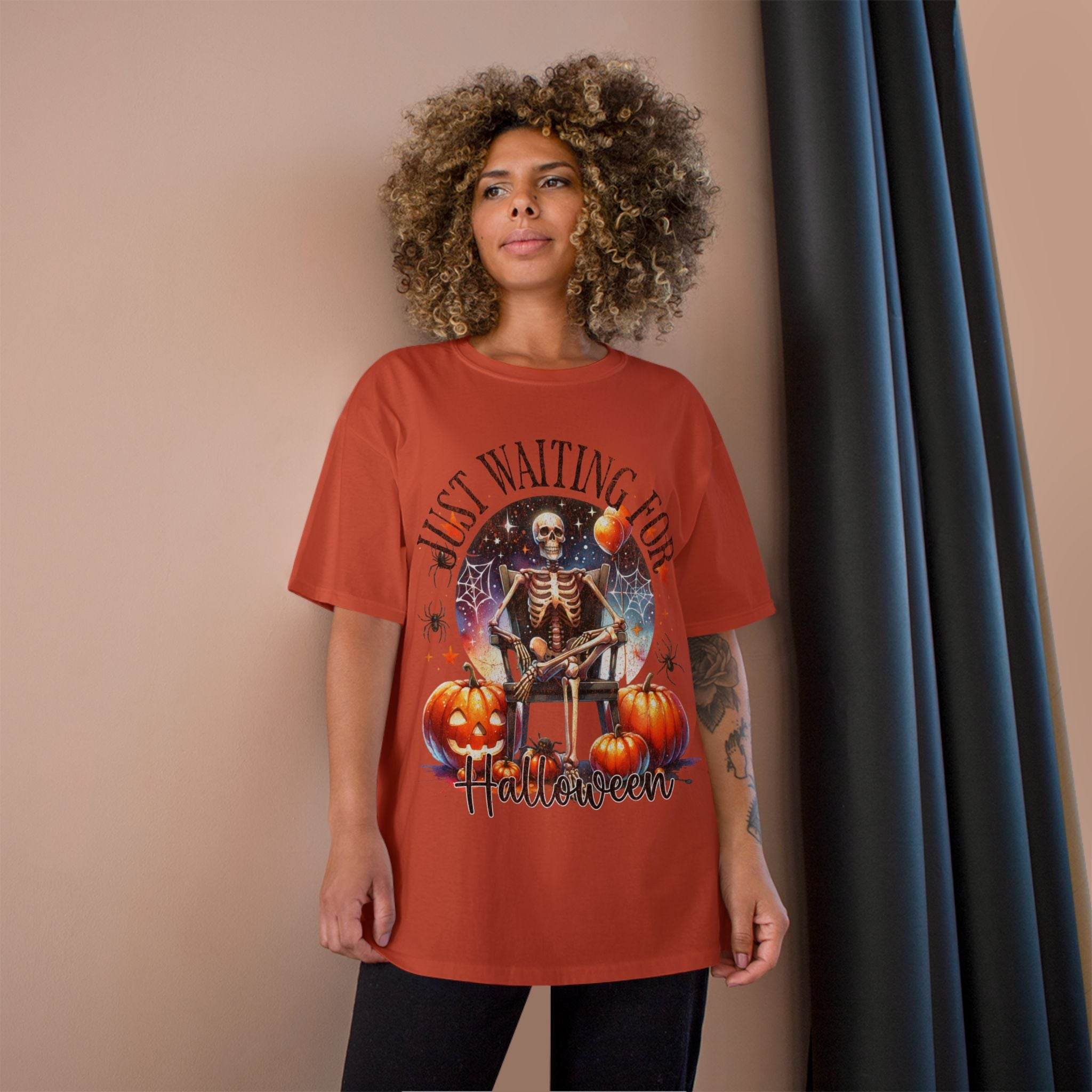 Woman wearing Printify eco-friendly Halloween t-shirt with skeleton and pumpkin design in rust color