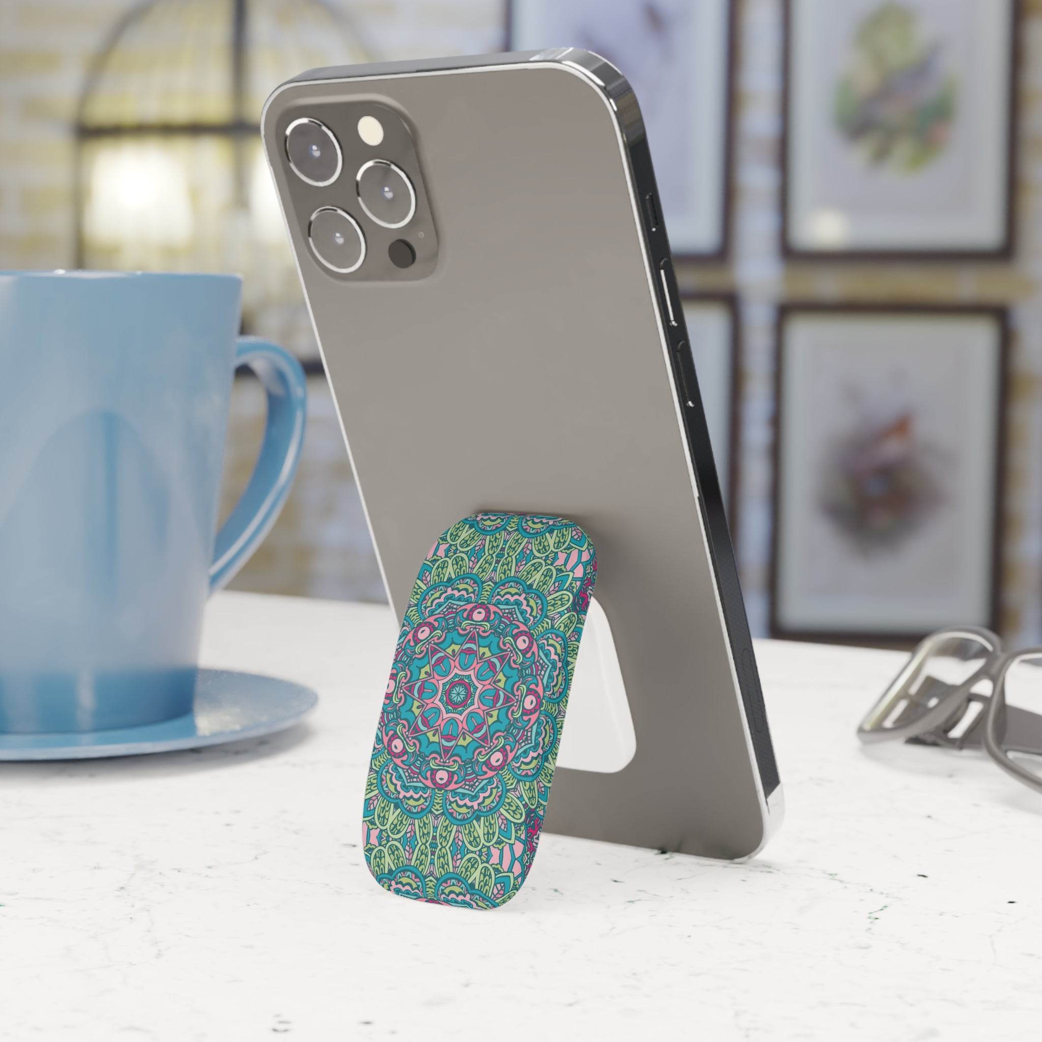 Printify eco-friendly phone grip with colorful mandala design attached to a silver smartphone on a white table