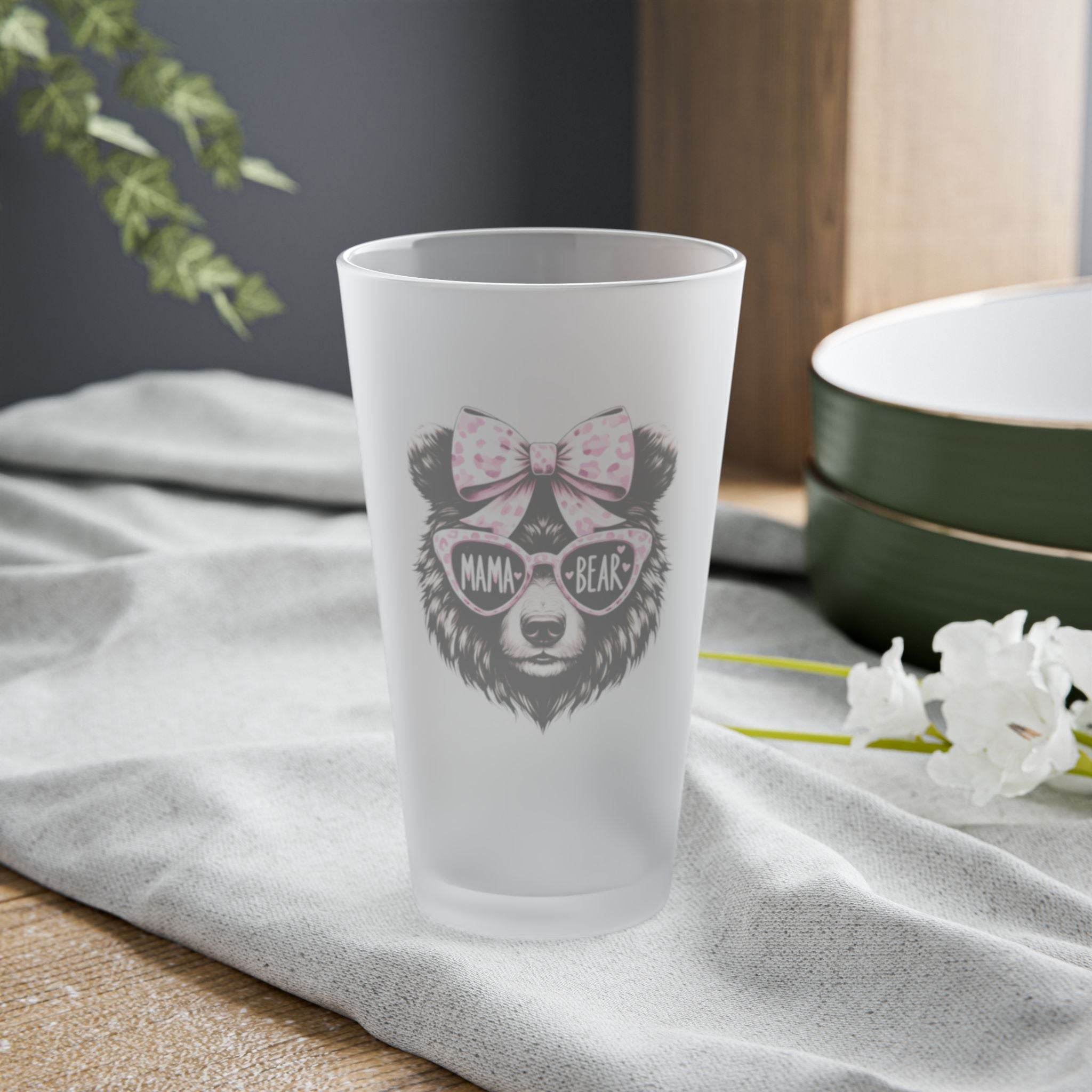 Printify eco-friendly pint glass with Mama Bear design and pink bow on a gray cloth