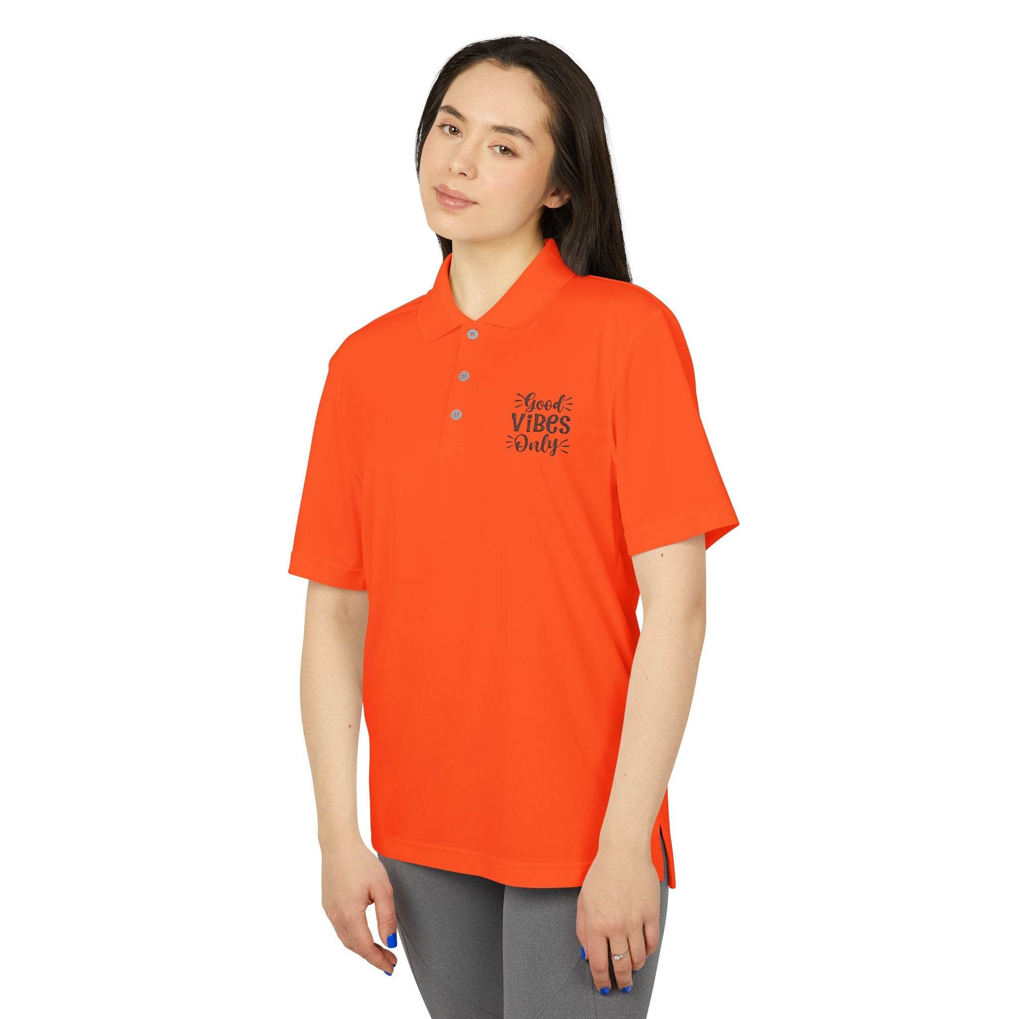 Woman wearing bright orange eco-friendly polo shirt with Good Vibes Only print by Printify