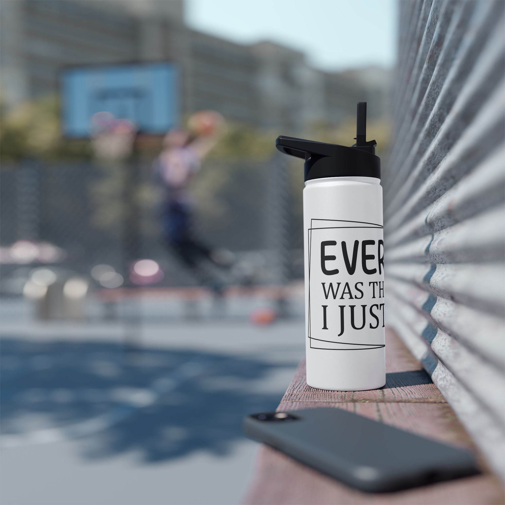Printify eco-friendly stainless steel water bottle with black lid placed on a bench near basketball court