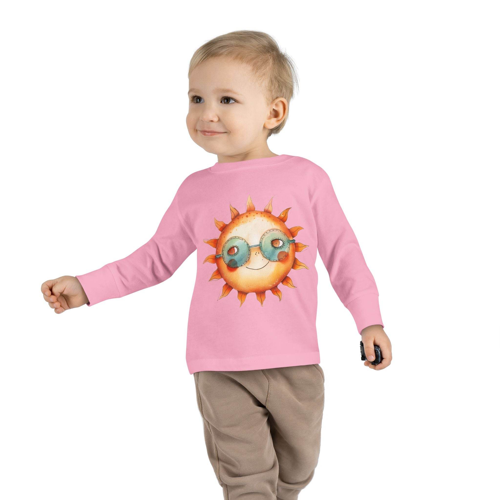 Toddler wearing a pink eco-friendly toddler long sleeve shirt with a sun graphic and sunglasses design
