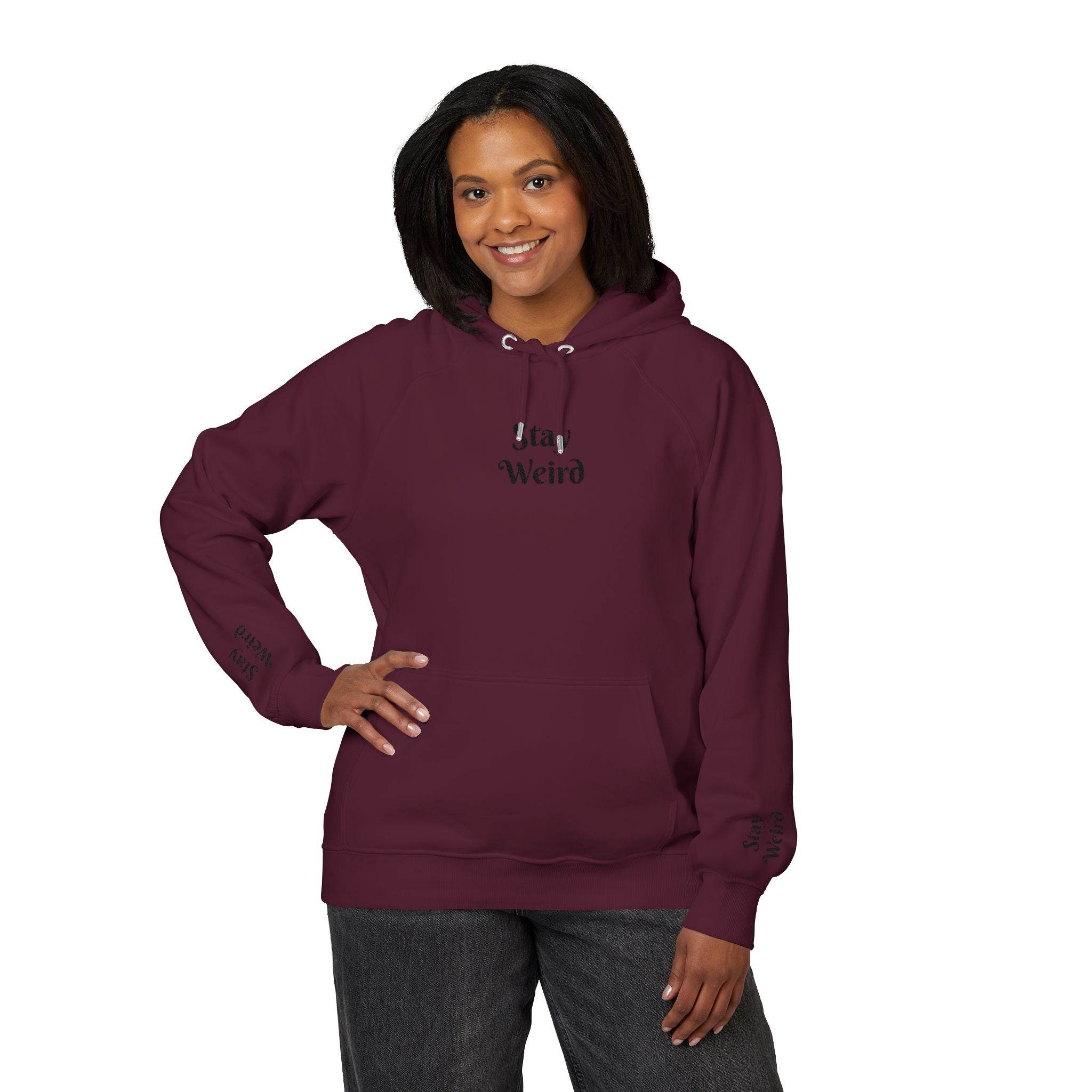 Printify eco friendly unisex hoodie in maroon with Stay Weird text worn by smiling woman