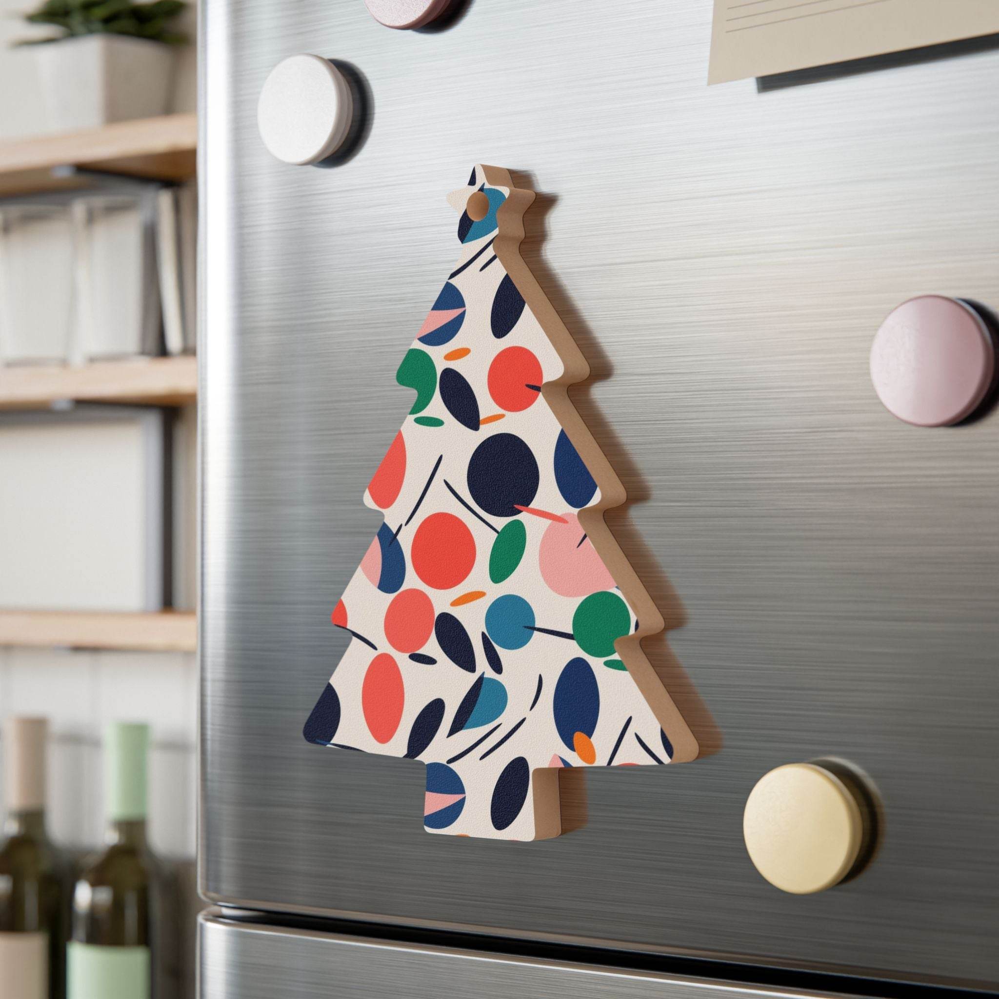 Printify eco-friendly wooden ornaments shaped like a Christmas tree with colorful leaf patterns on a silver refrigerator