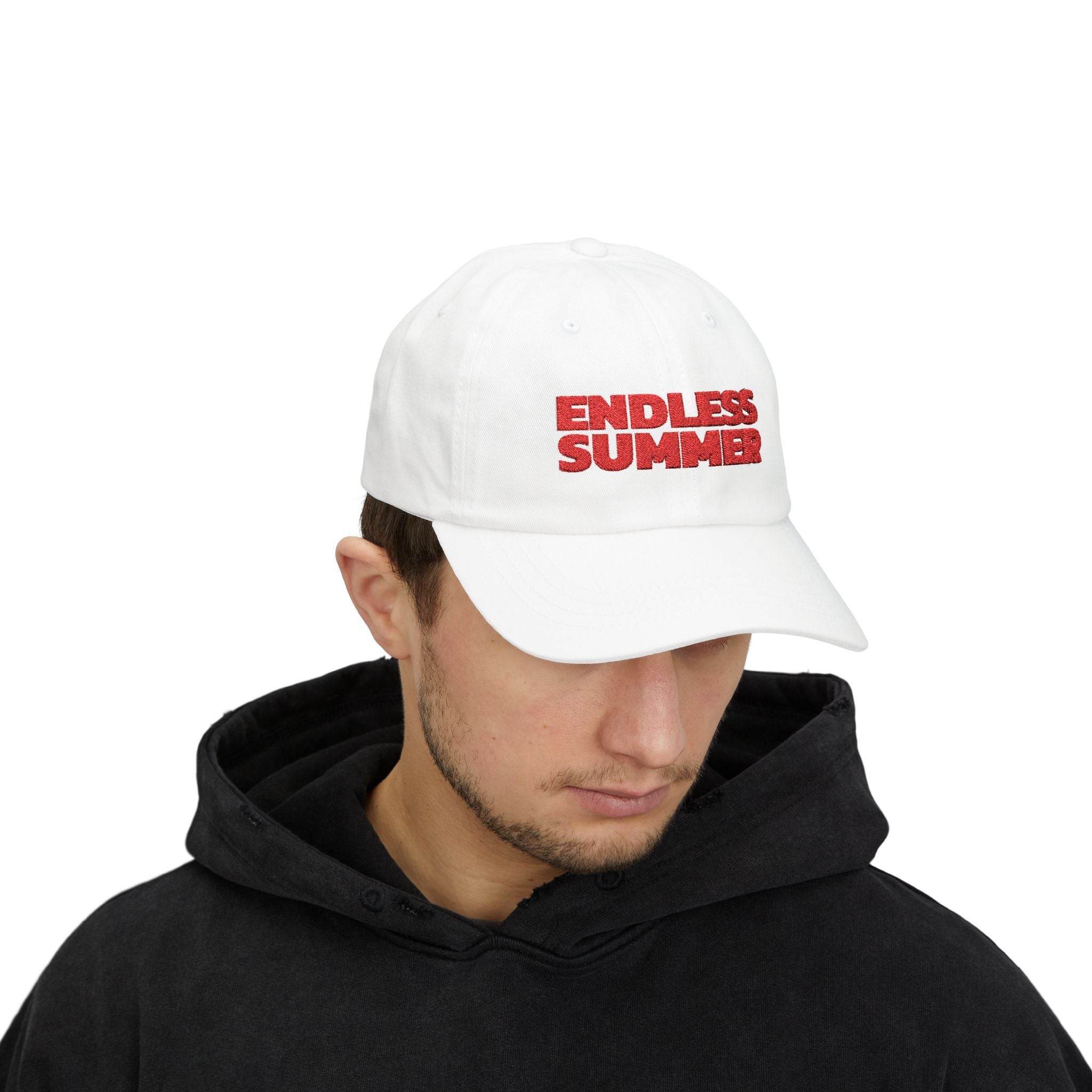 White eco-friendly dad cap with red Endless Summer text worn by man in black hoodie
