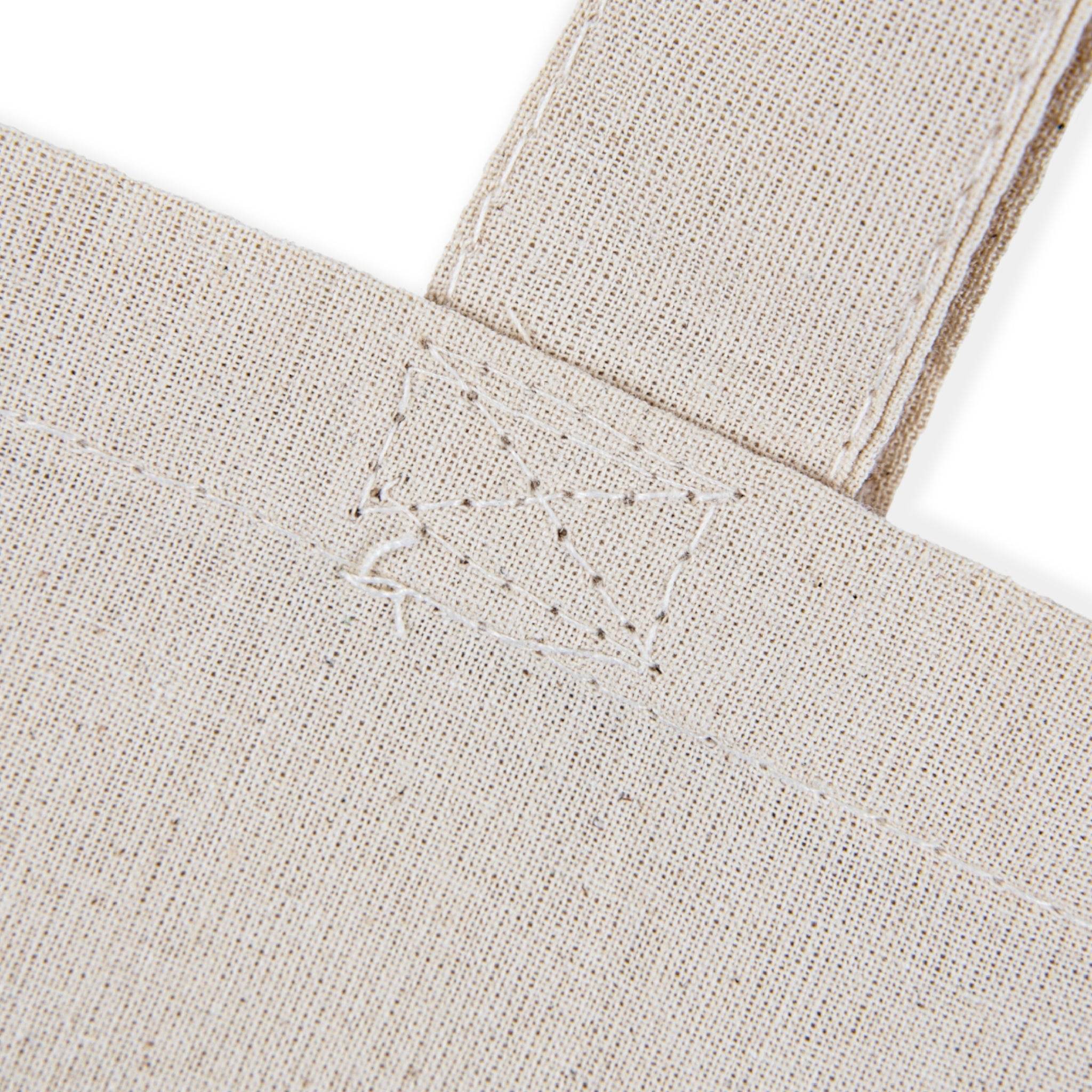 eco-friendly paw print tote bag natural canvas closeup showing reinforced strap stitching and textured fabric