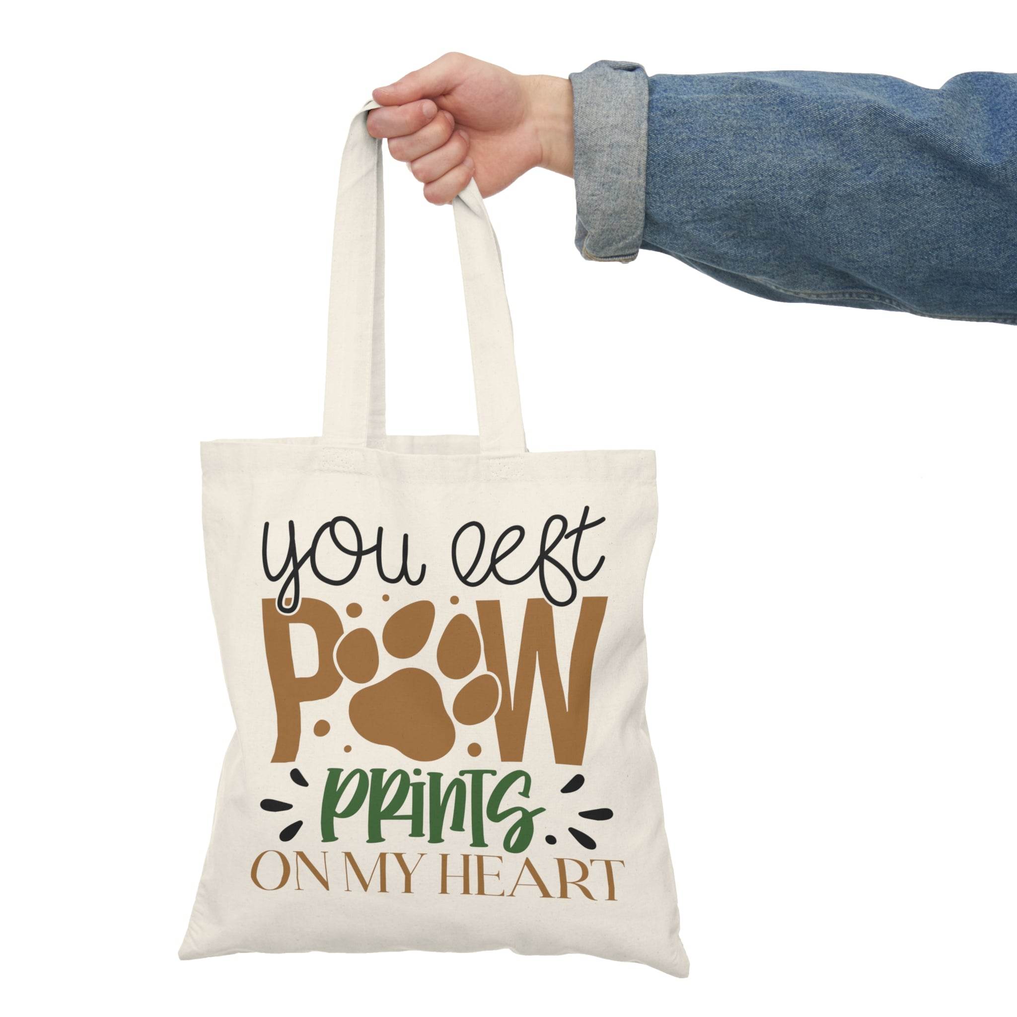Printify eco-friendly paw print tote bag with You left paw prints on my heart design held by hand