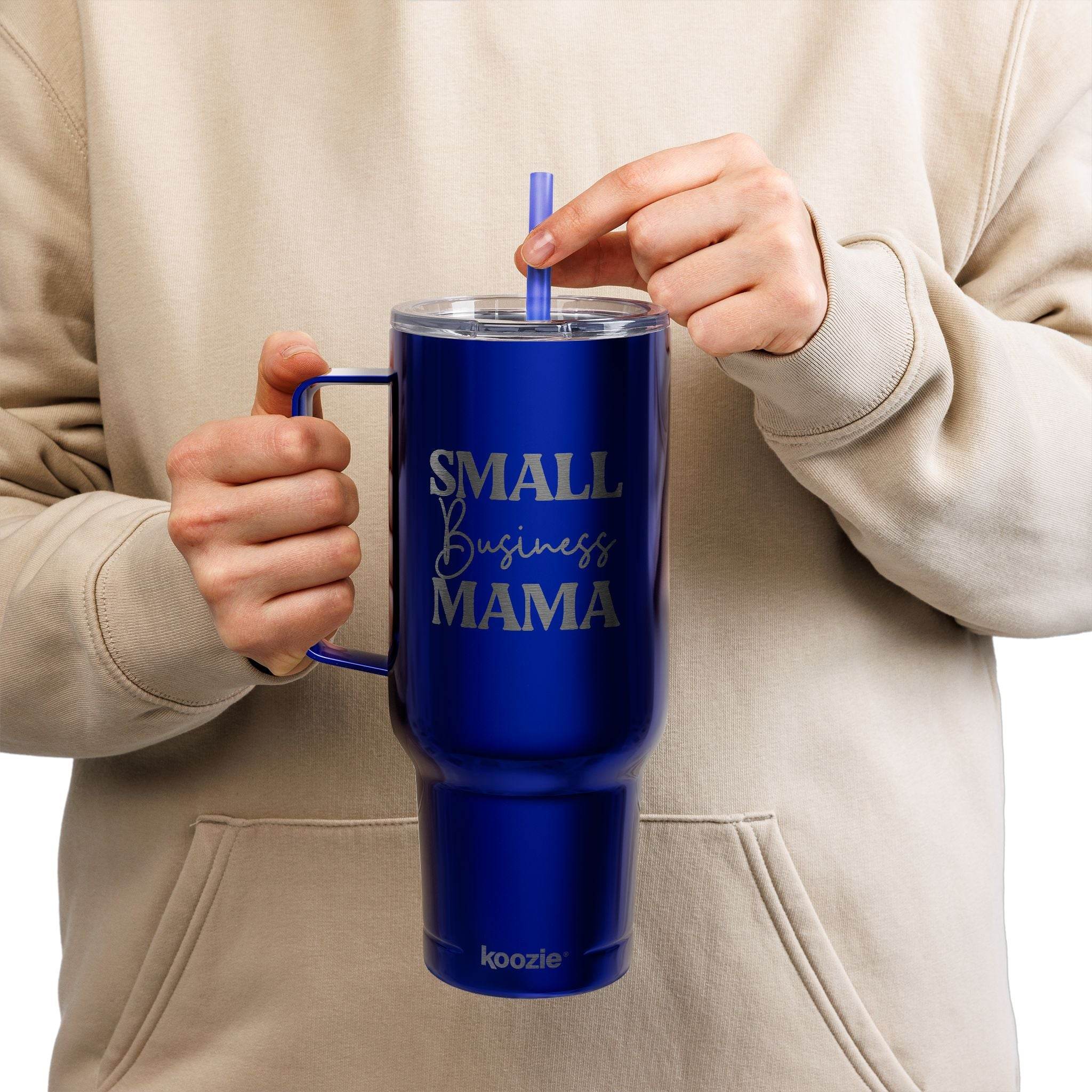 Blue eco-friendly insulated tumbler with handle and straw held by person wearing beige hoodie