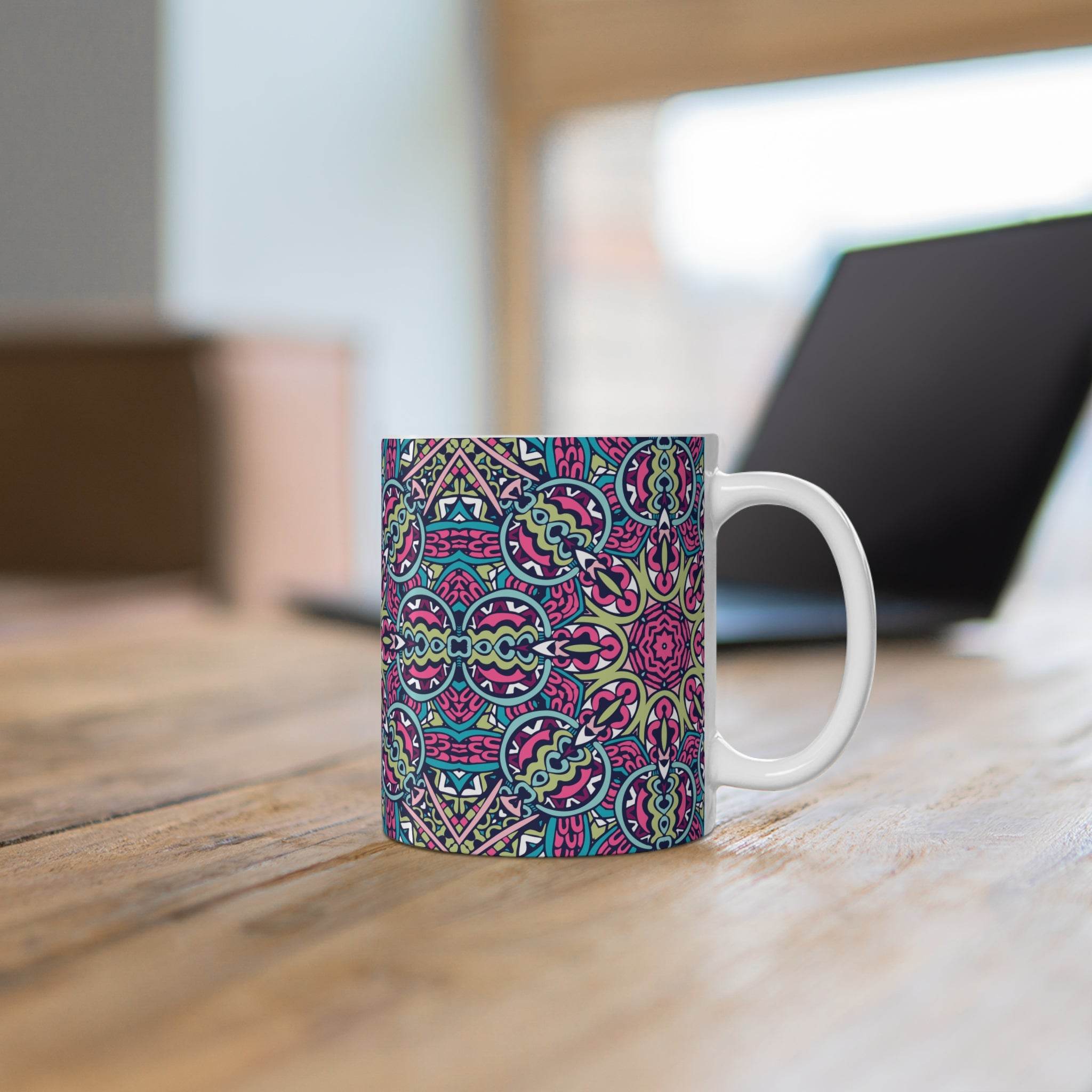 Printify mandala design eco mug with colorful intricate patterns on wooden table near laptop