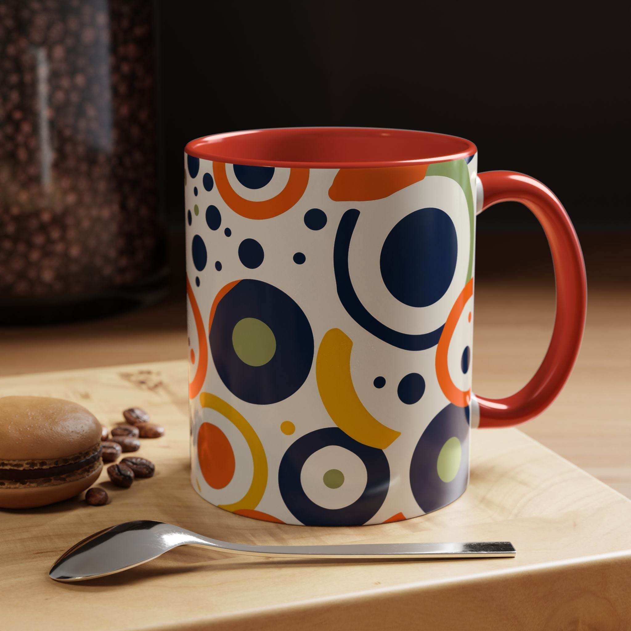 Printify pop art coffee mug with colorful circular patterns and red handle on wooden table