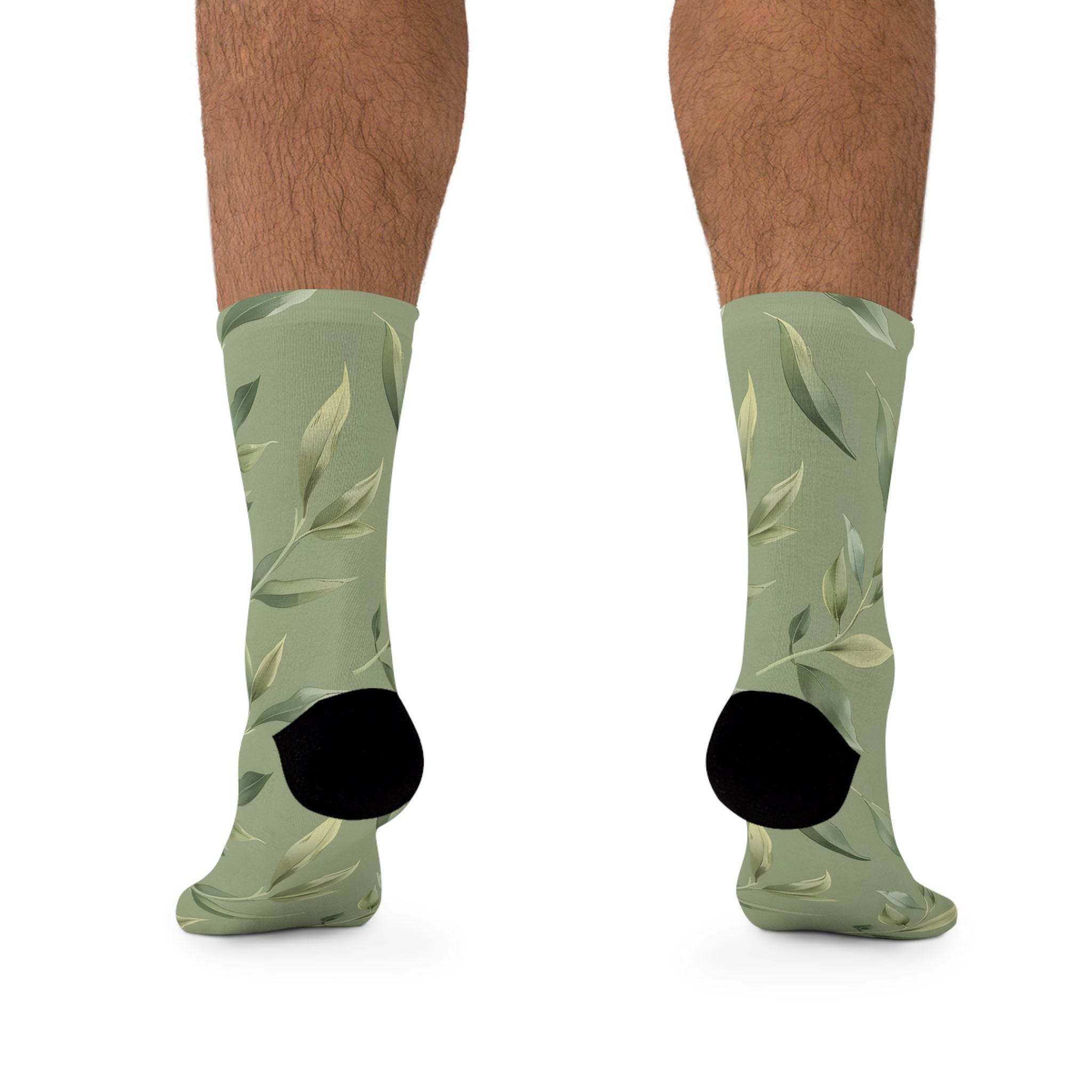 Printify green leaf pattern recycled poly socks with black heel and toe on model legs