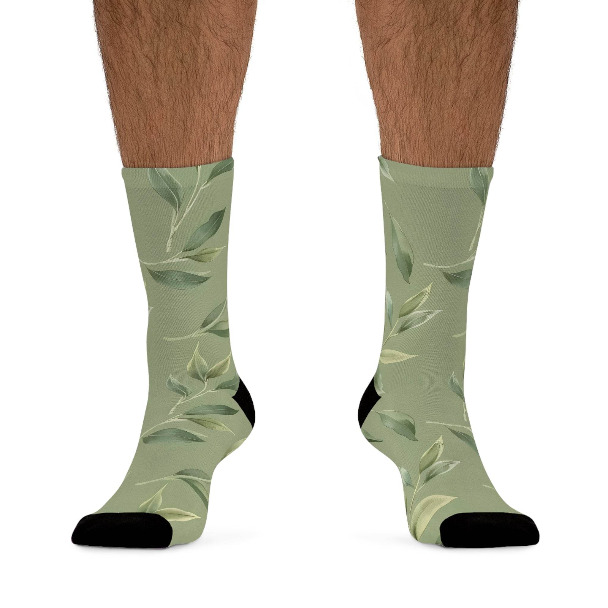 Printify green leafy design recycled poly socks with black toe and heel on male legs