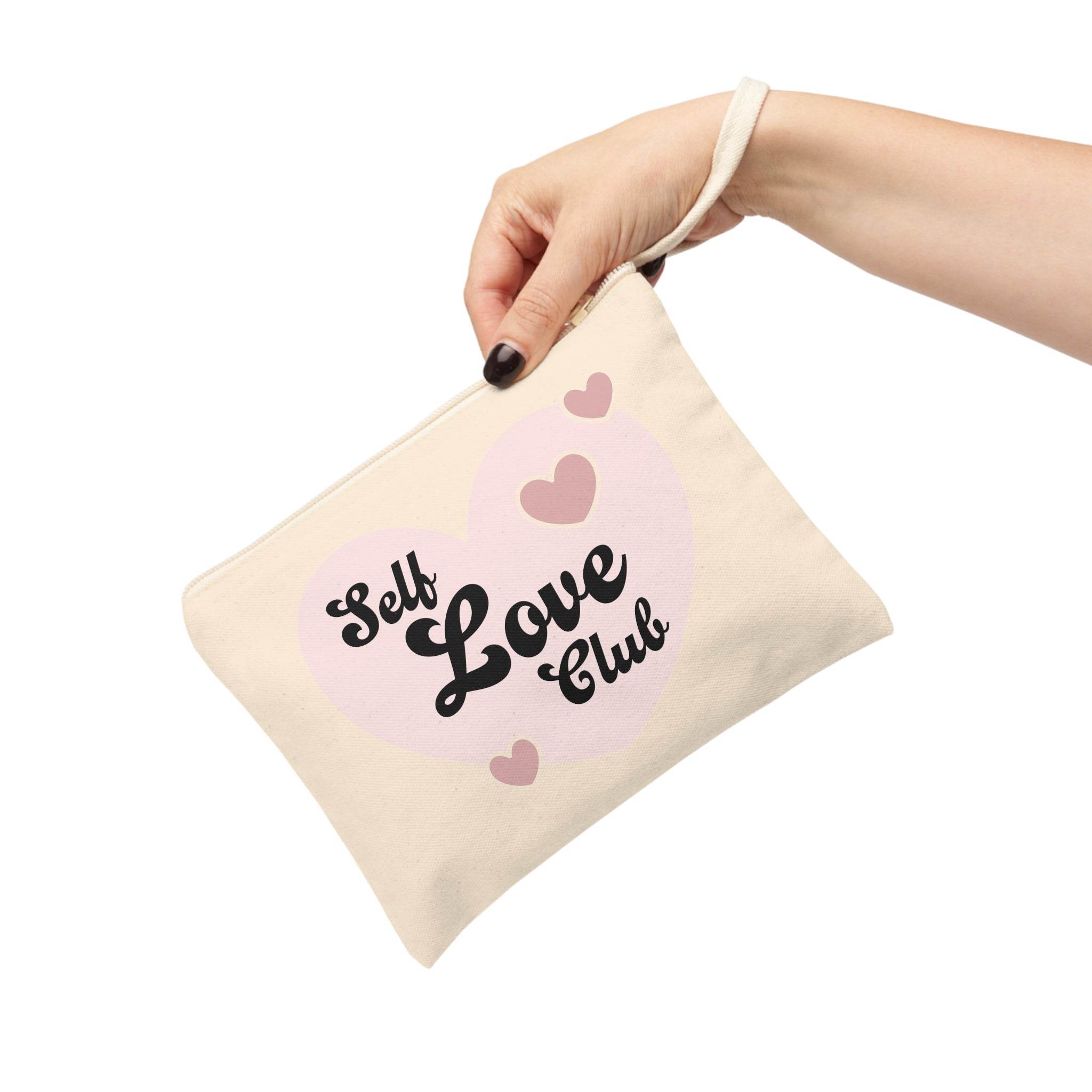 Printify eco-friendly zipper pouch with Self Love Club design held by hand with strap