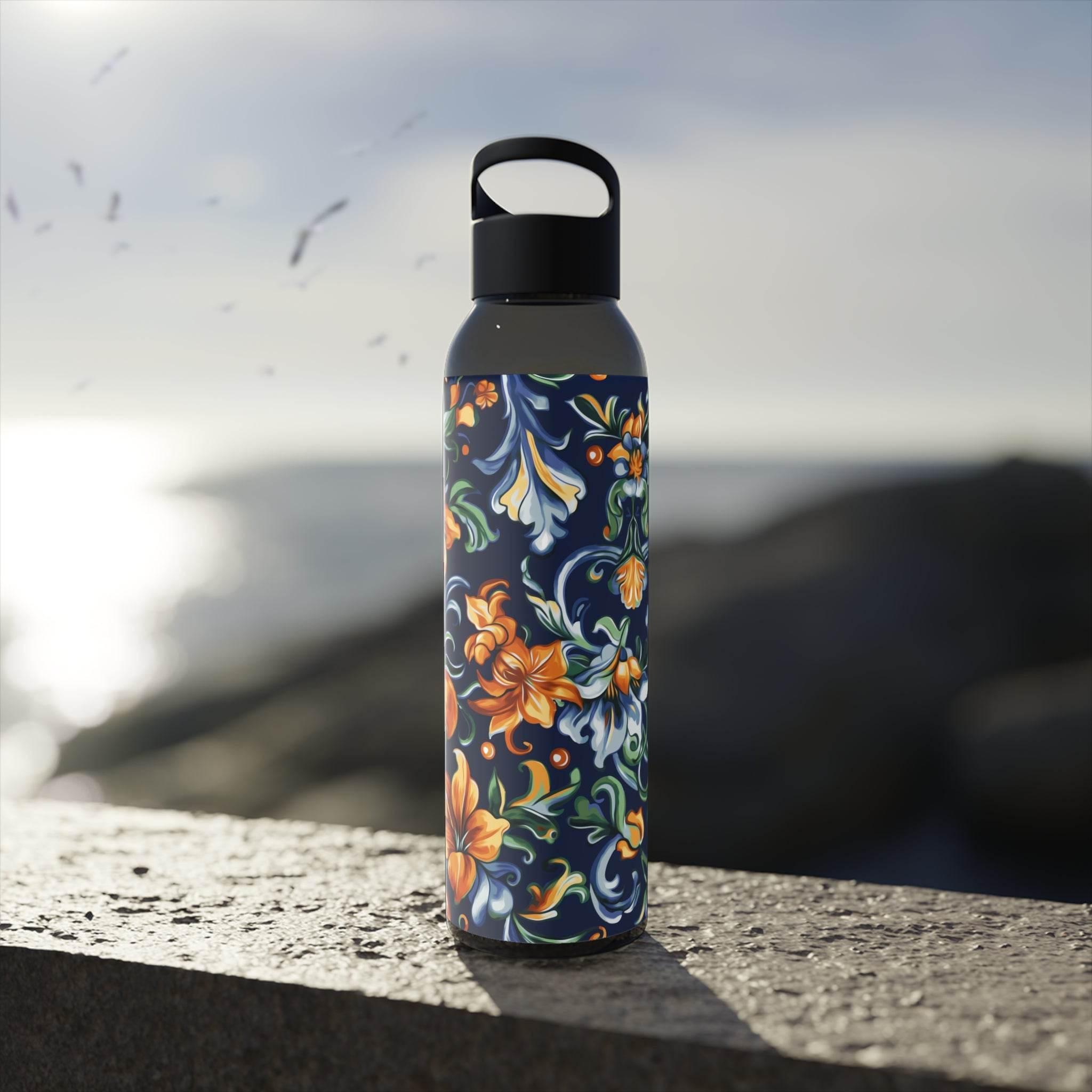 Printify stylish eco water bottle with colorful floral design standing on a stone surface outdoors