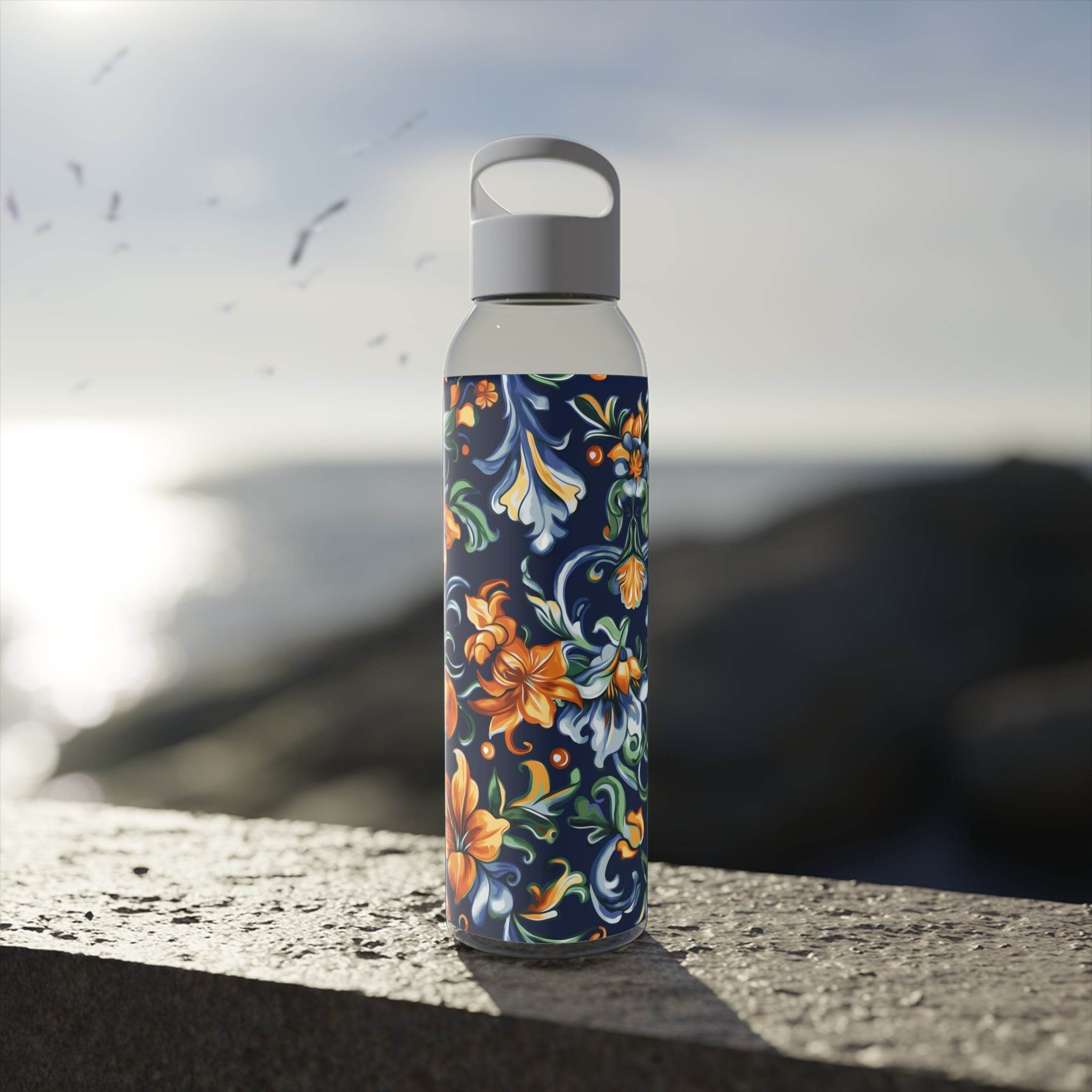 Printify stylish eco water bottle with colorful floral design on a coastal rock surface