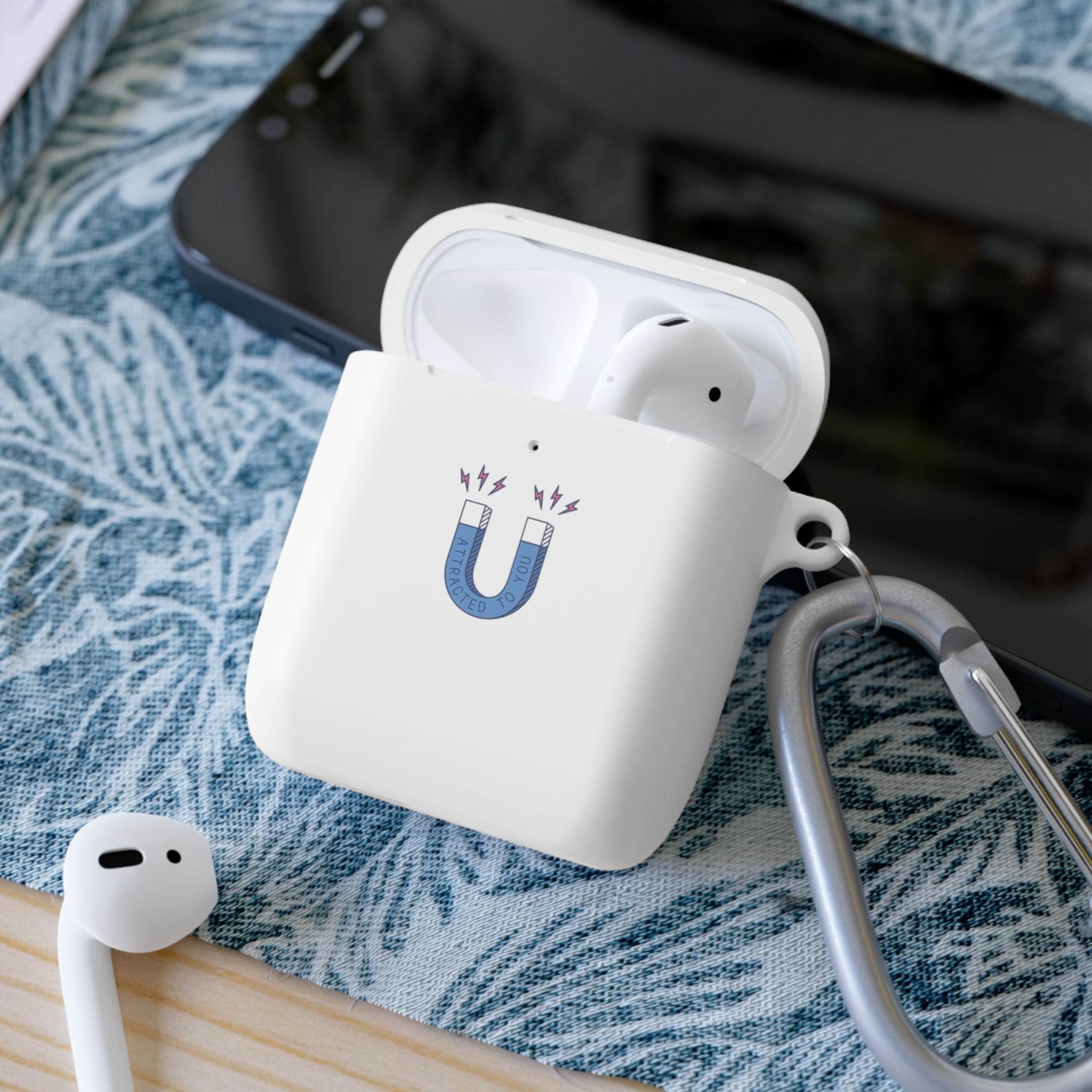 Printify sustainable AirPods Pro cover with magnet design and attached carabiner clip on blue fabric