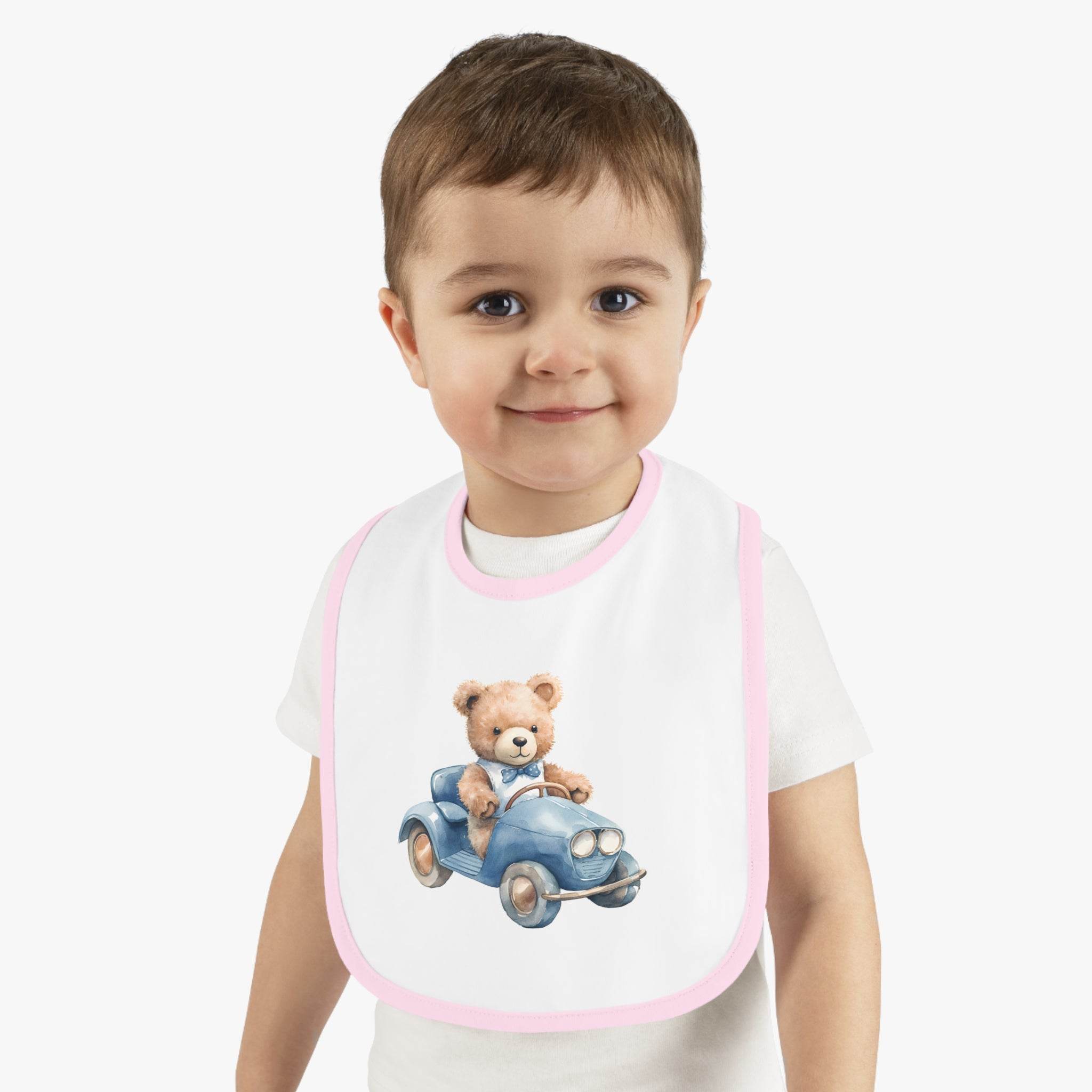 Toddler wearing a sustainable baby bib with pink trim and a teddy bear driving a blue car design