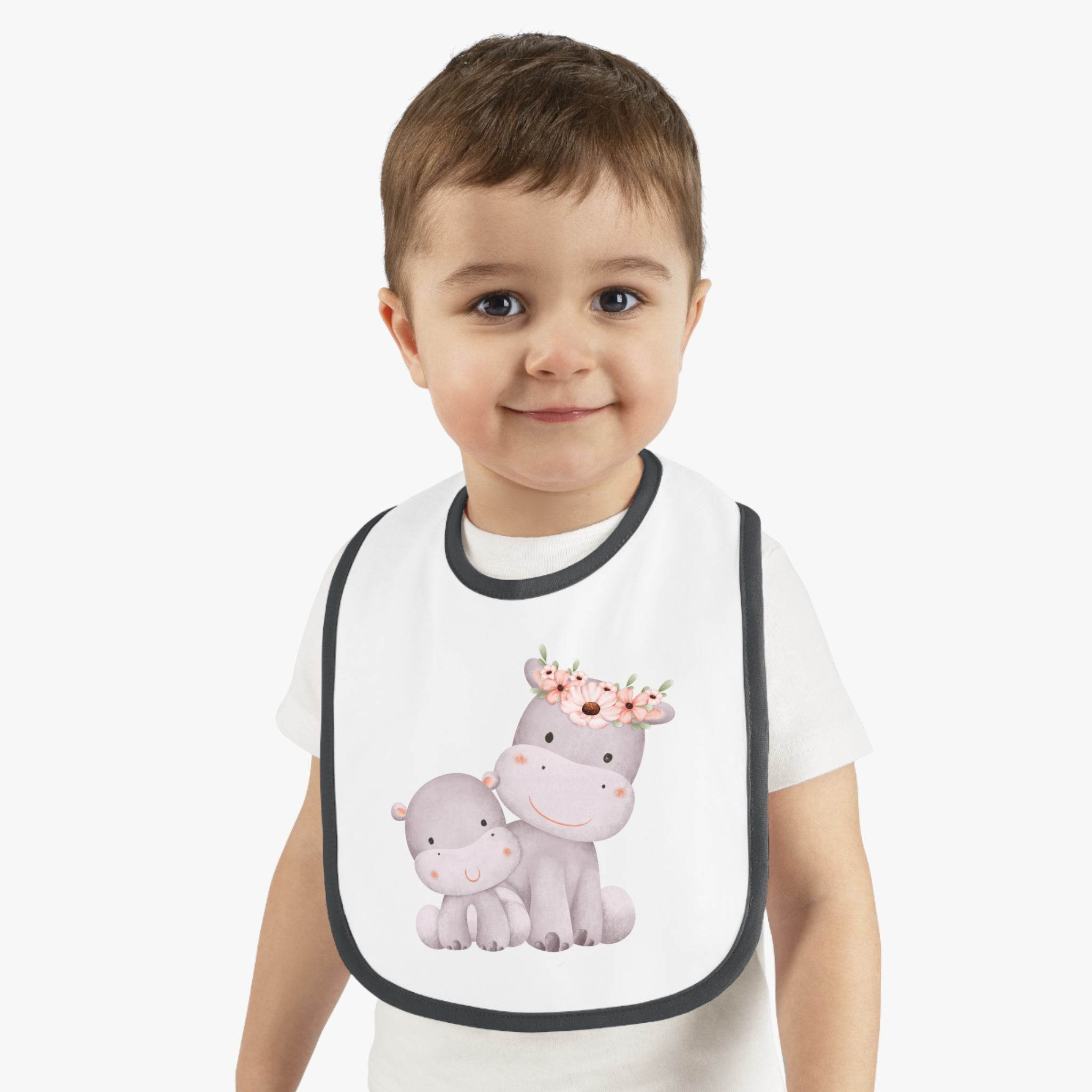 Toddler wearing a sustainable baby jersey bib with cute hippo design by Printify