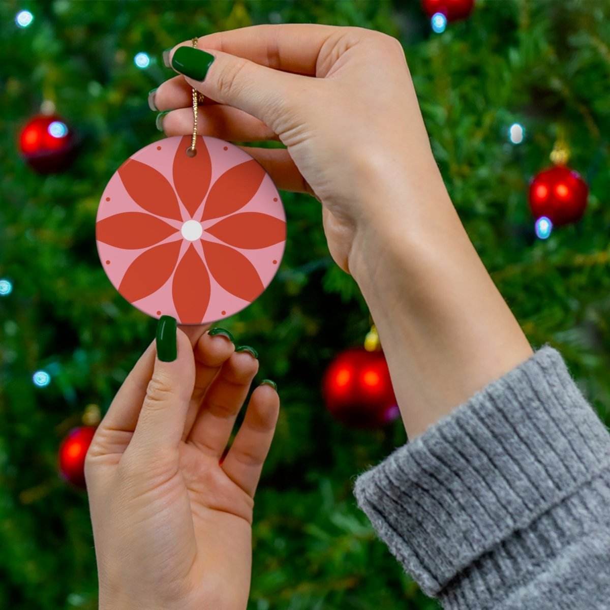 Hand holding sustainable ceramic decor red flower design ornament for seasonal decorations