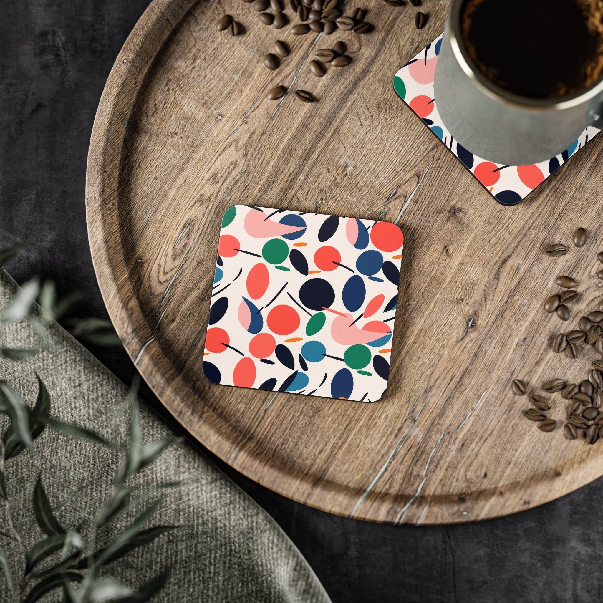 Colorful sustainable drink coasters with abstract leaf pattern on wooden tray holding coffee cup